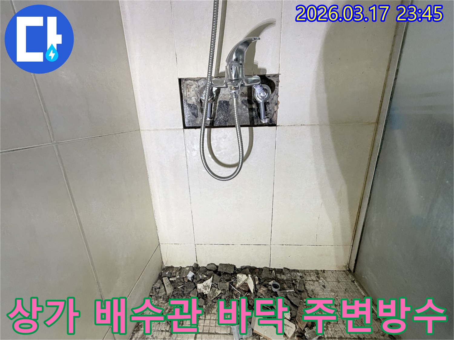 화성시 병점구 상가 샤워실에서-배수관 누수 교체 및 주변 방수를 위해-바닥 타일이 파손된 채로-공사가 진행 중인 모습입니다.