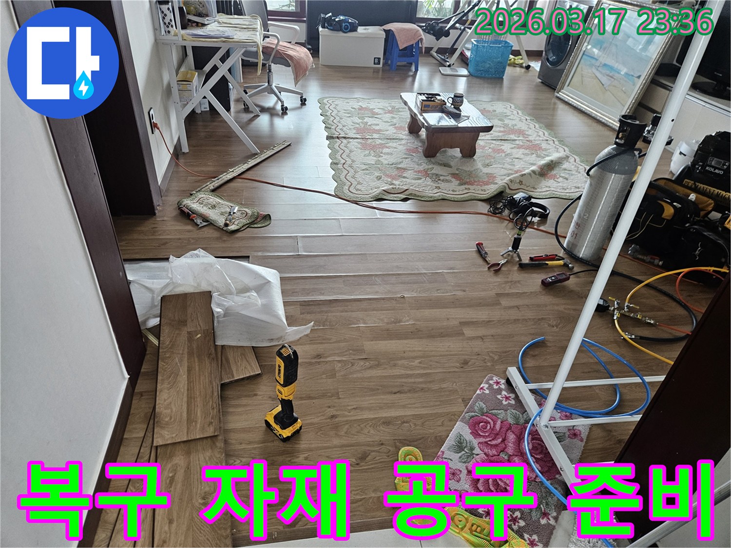 화성시 병점구의 누수 현장에서-바닥 복구를 위한 새로운 마루 자재와-전동 공구가 준비된 모습