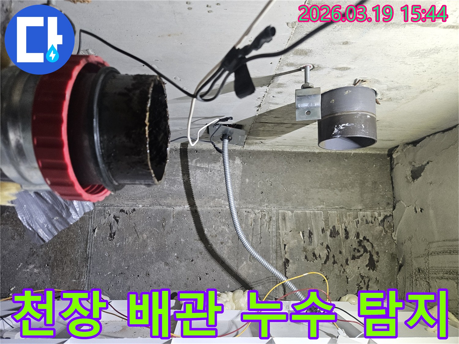누수 공사 현장에서-천장 배관과-전기 배선이-복잡하게-얽혀있는-모습을-보여줍니다