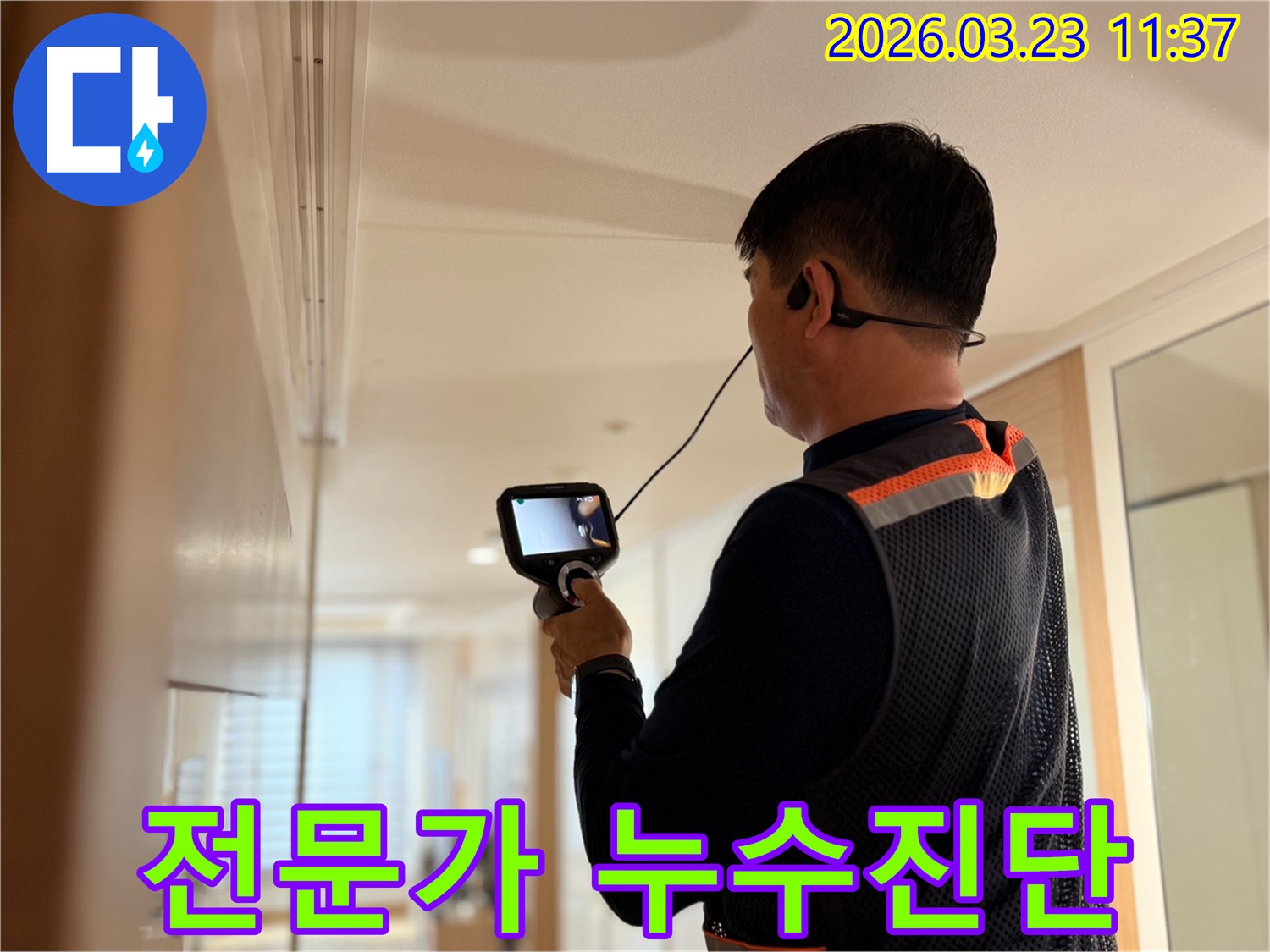 누수 전문가가 최신 탐지 장비를 활용하여 아파트 내부의 누수 지점을 면밀히 조사하는 장면