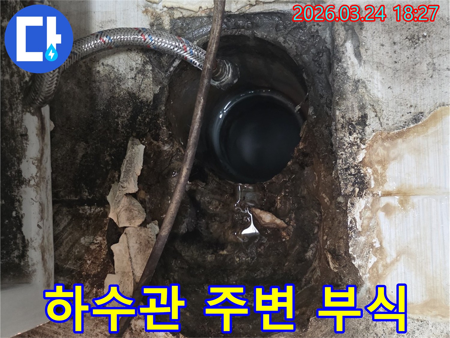 오래된 하수관 주변 벽면이 물에 젖어-심하게 부식되고 손상된 상태를 보여줍니다.