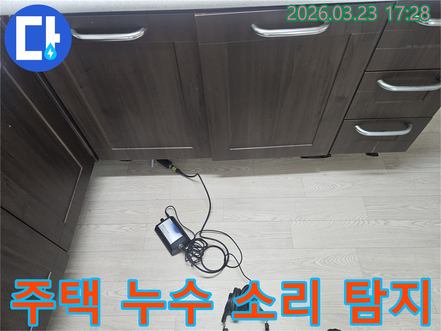 용인 주택의 숨겨진 누수를 찾기 위해-고성능 청음식 탐지 장비를 활용하여-엔지니어가 집중적으로 소리를 분석하는 장면