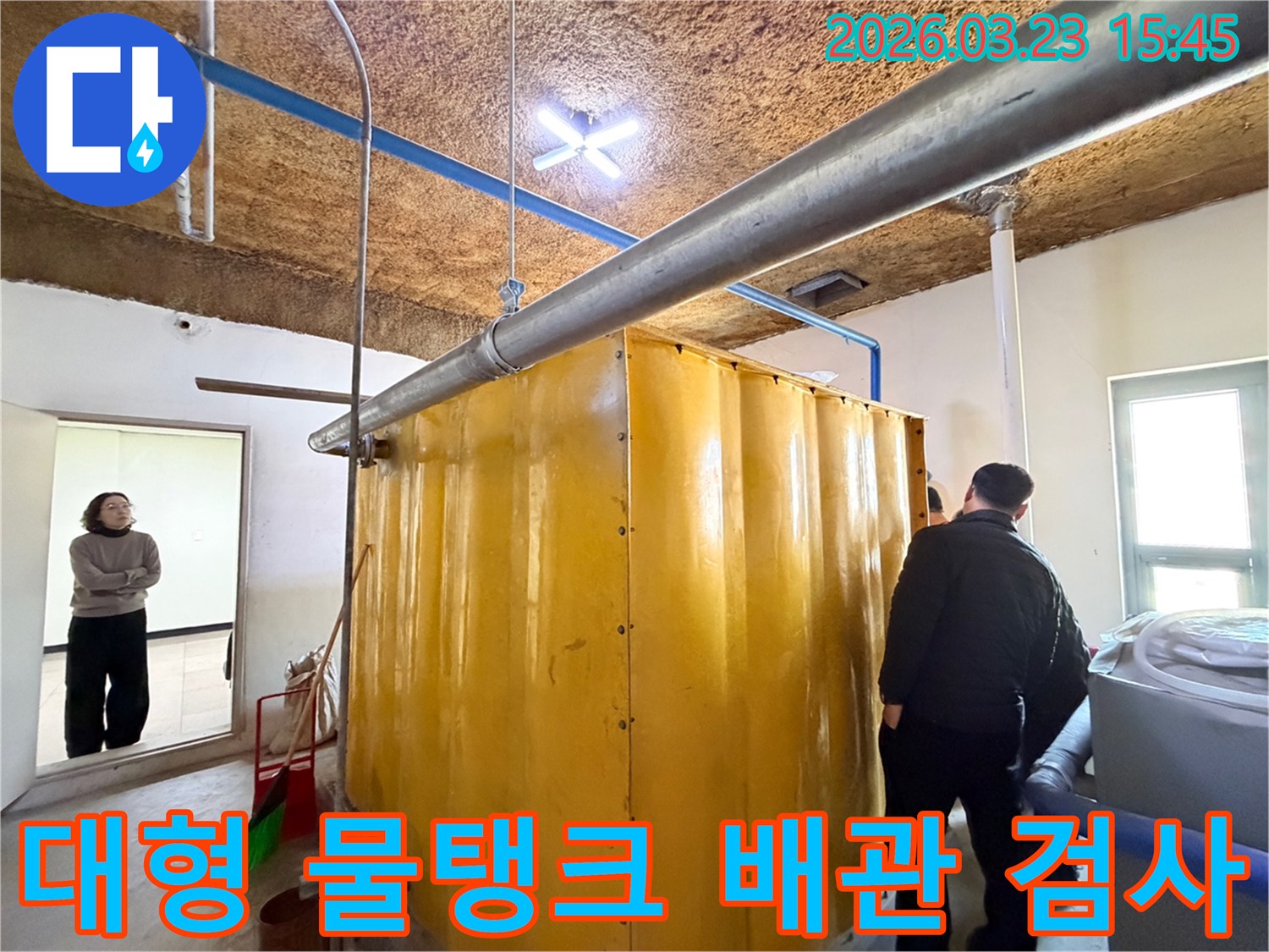 동대문구-현장에서-누수-전문가가-대형-물탱크-주변의-배관-연결부를-정밀하게-검사하는-모습
