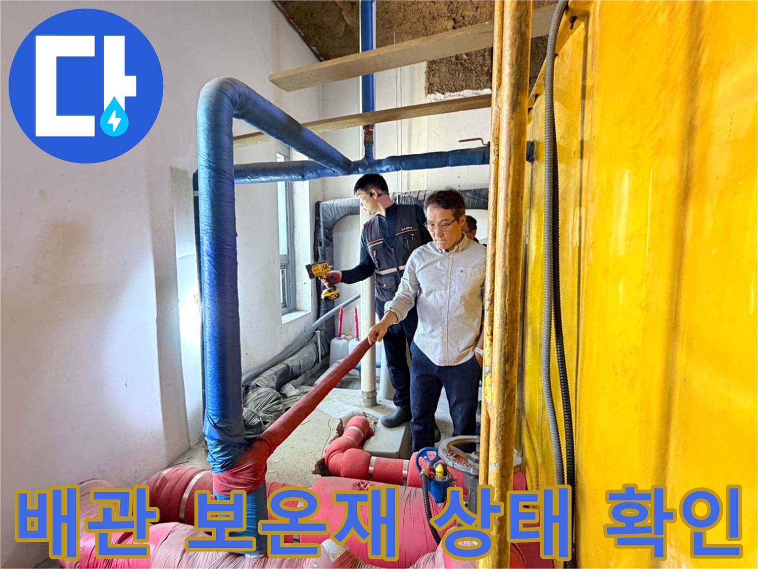 두 명의 작업자가 분홍색 배관과 파란색 배관이 교차하는 지점을 면밀히 관찰하고 있습니다.