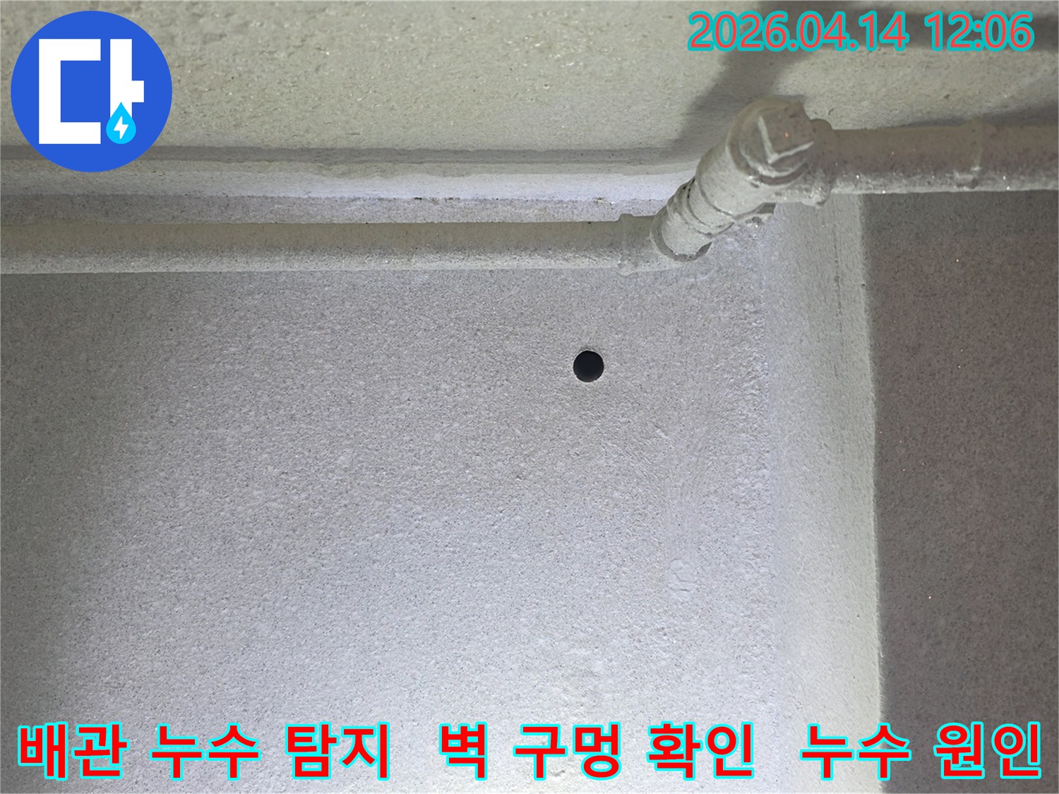 이 사진은-갈현동 현대아파트의-배관 누수 지점을 찾기 위해-벽에 뚫은 작은 구멍과-주변 배관을 보여줍니다