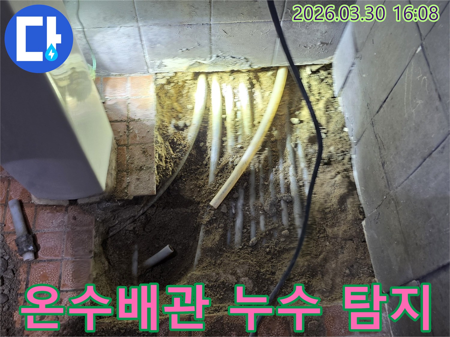 파주 문산의 온수배관 누수 현장에서-바닥 파쇄 후-노출된 온수배관을 점검하는 모습입니다.