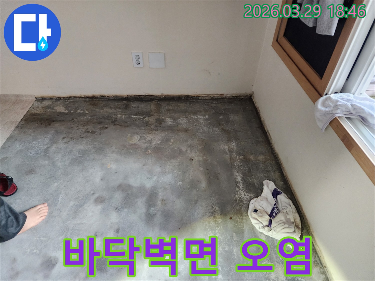 이 이미지는-남양주 오남읍의 한 아파트에서-바닥과 벽면 경계에-습기로 인한-오염과 곰팡이가-발생한 누수 현장을-보여주고 있습니다