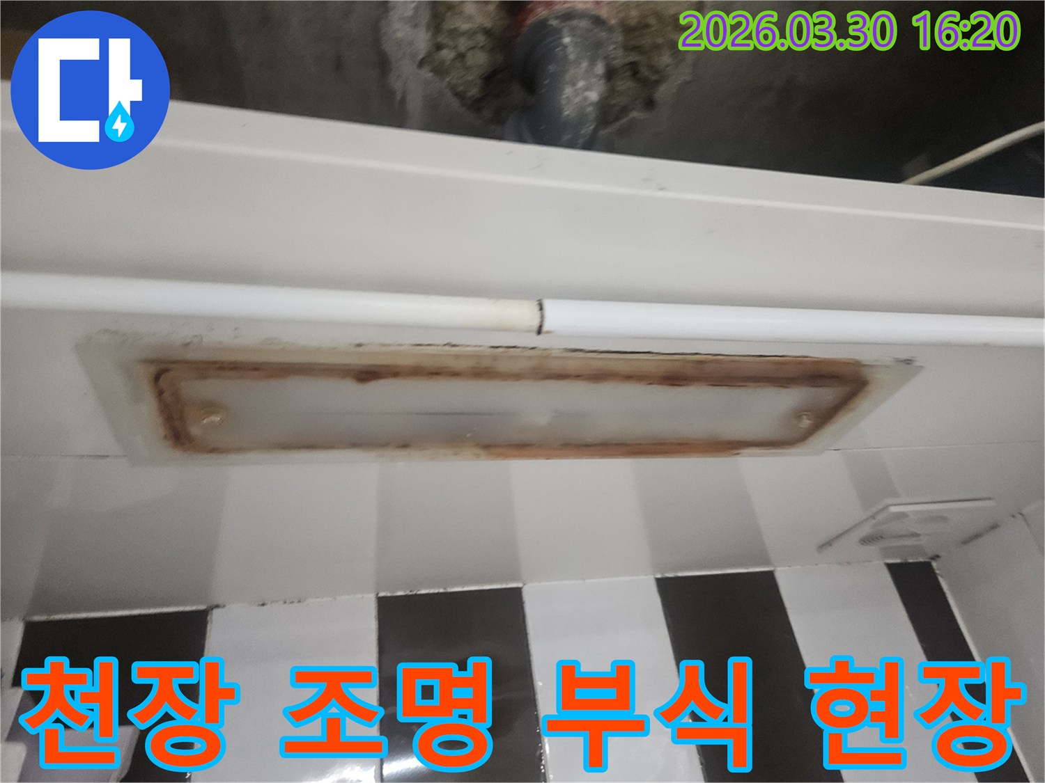 오래된 건물의-화장실 천장에서-배관 누수로 인해-조명 주변이-심하게 부식된-모습을 담고 있습니다