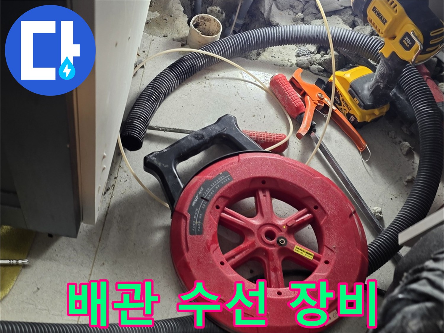 싱크대 아래 배관 작업을 위해 준비된 드릴과 호스 릴