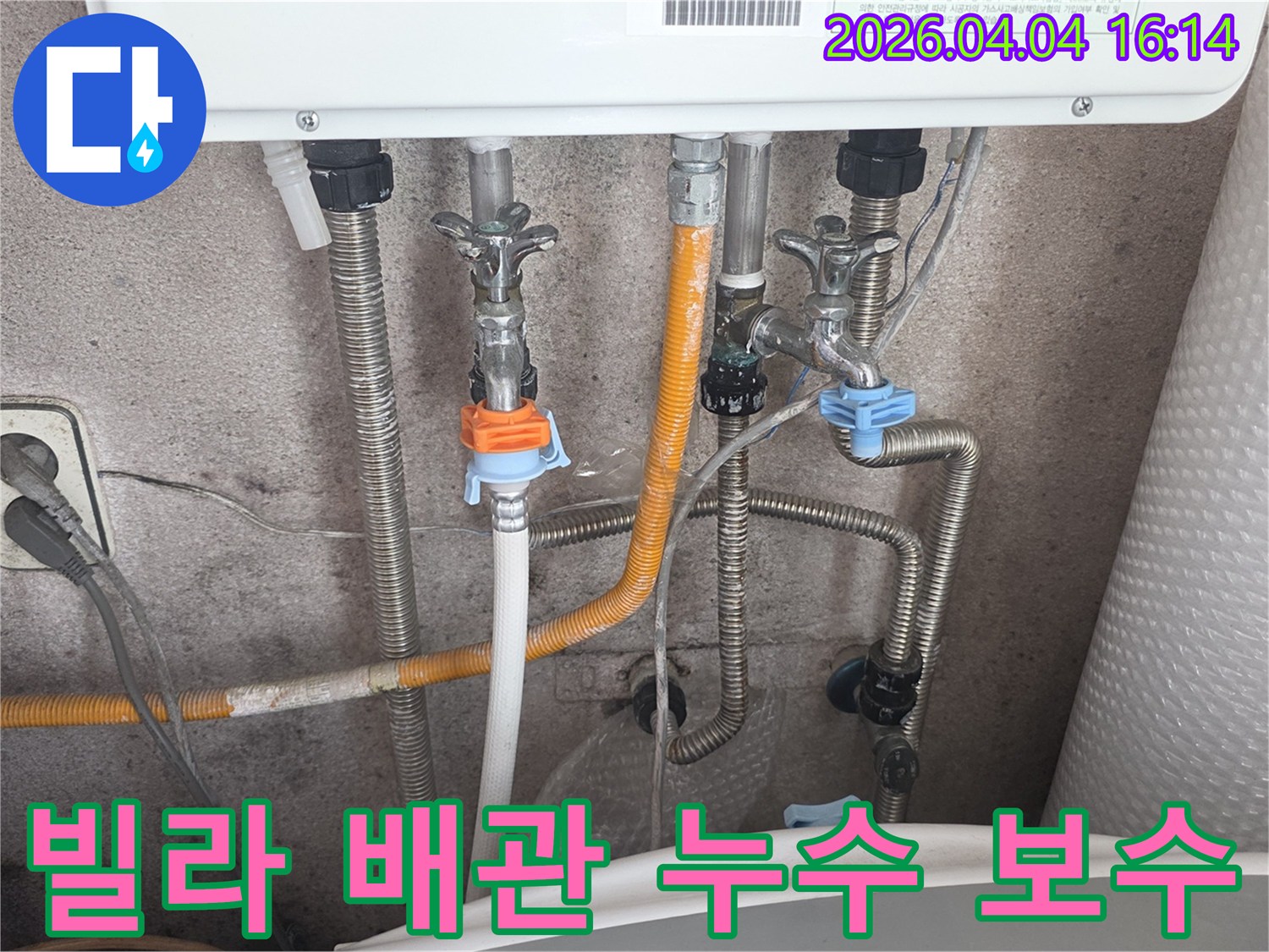 빌라 보일러 하단의 복잡한 배관 시스템-수도-가스-온수관의 연결 상태를-누수 전문가가 면밀히 확인하고 보수하는 장면