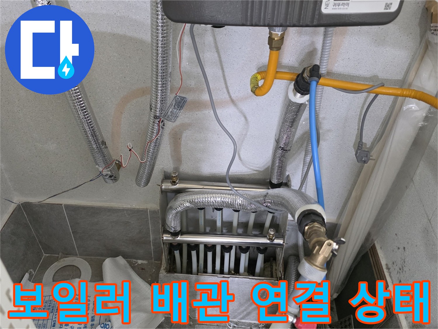보일러 하단부의 은색 보온재 배관과 노란색 온수 호스