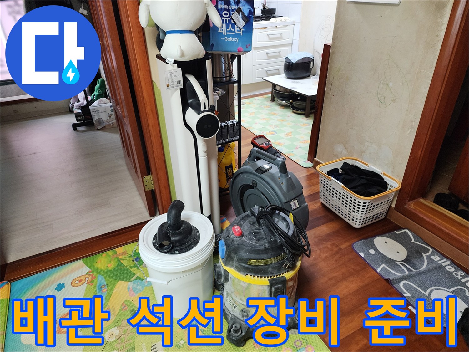 세탁실 바닥에 놓인 강력한 흡입력을 가진 산업용 석션기와 작업 도구들