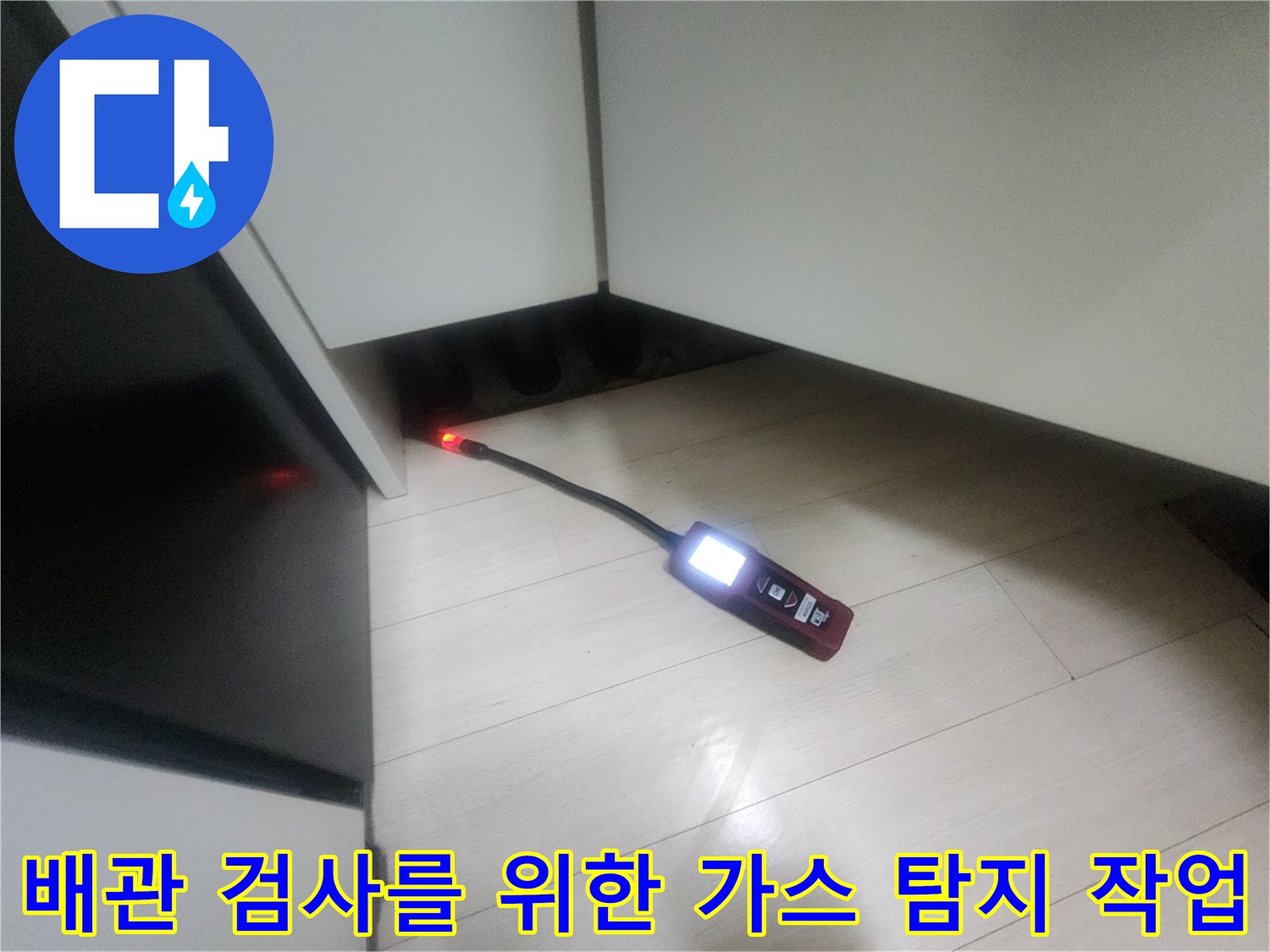 가스 탐지 장비를 사용하여 싱크대 하부 배관의 누수 여부를 면밀히 조사하고 있습니다.