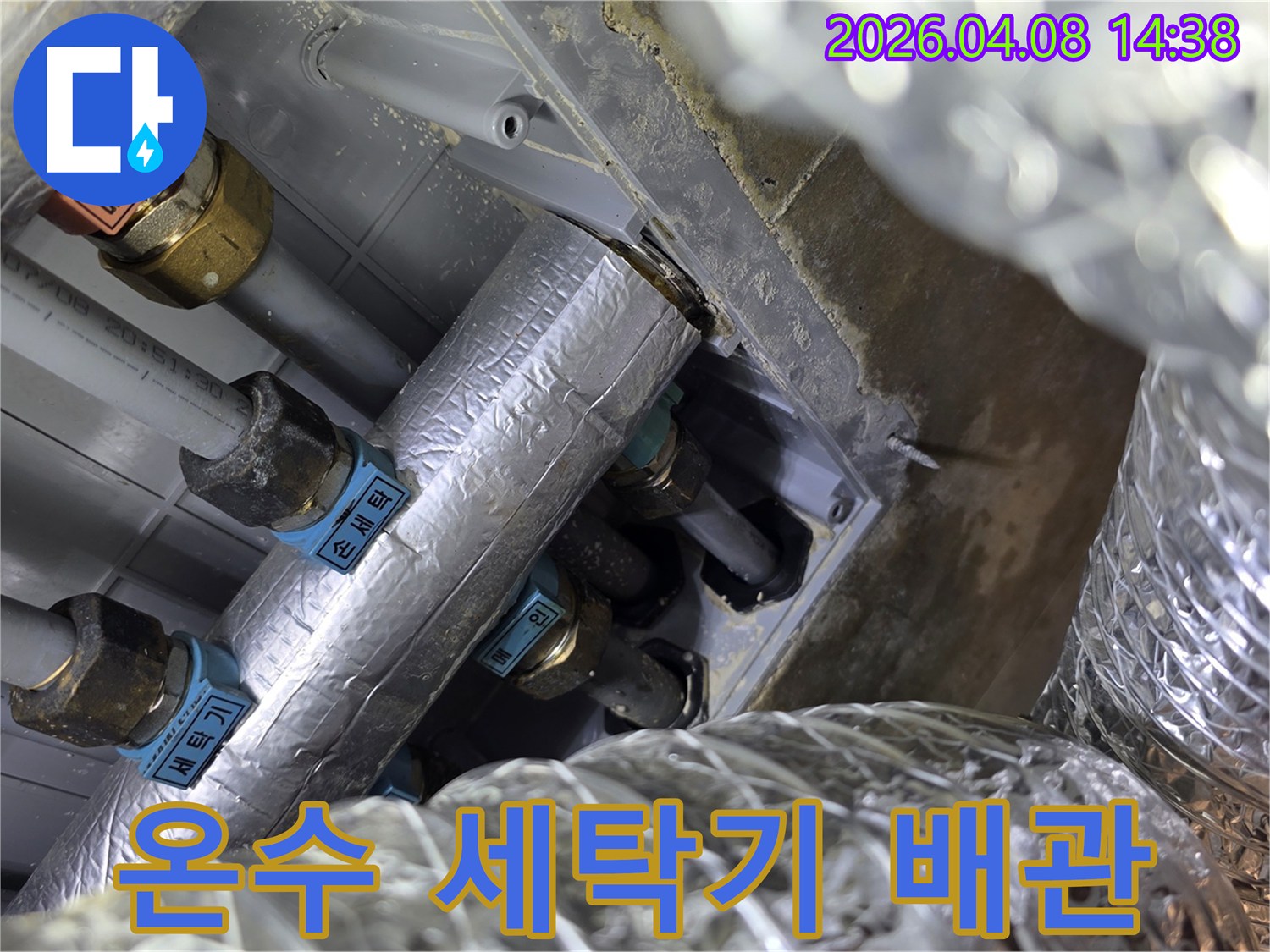 세탁실 온수 배관의 단열 상태를 확인하며-잠재적 누수 지점을 탐색하고 있습니다.