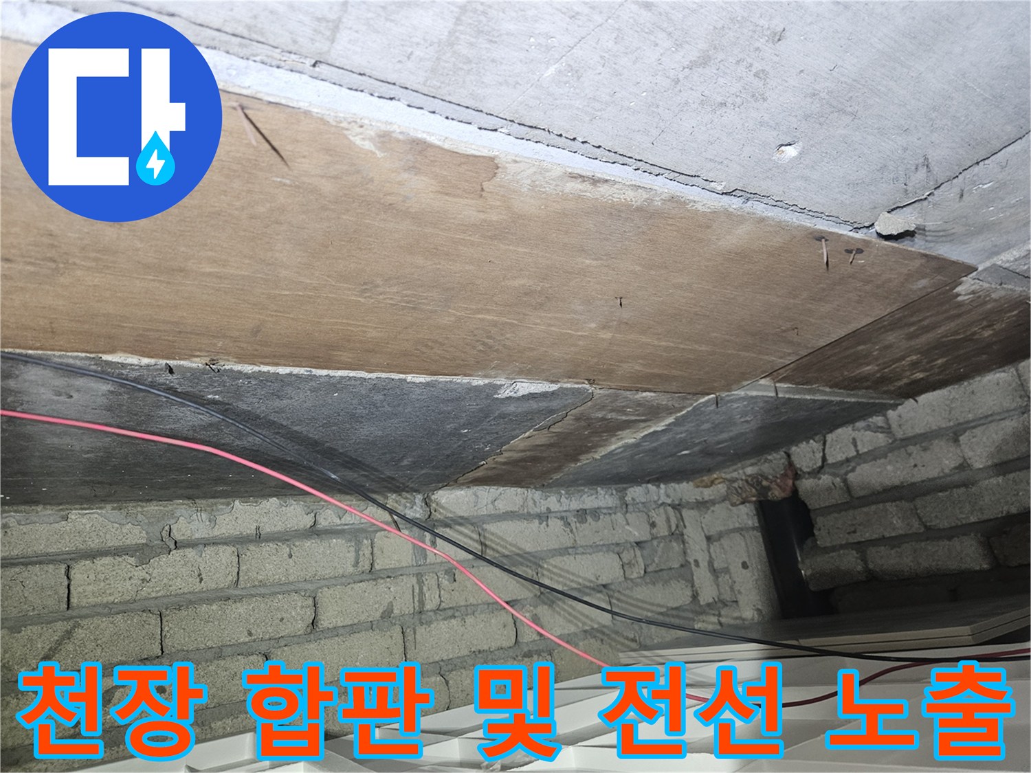 건물 천장 내부의 나무 판재와 전기 배선의 모습