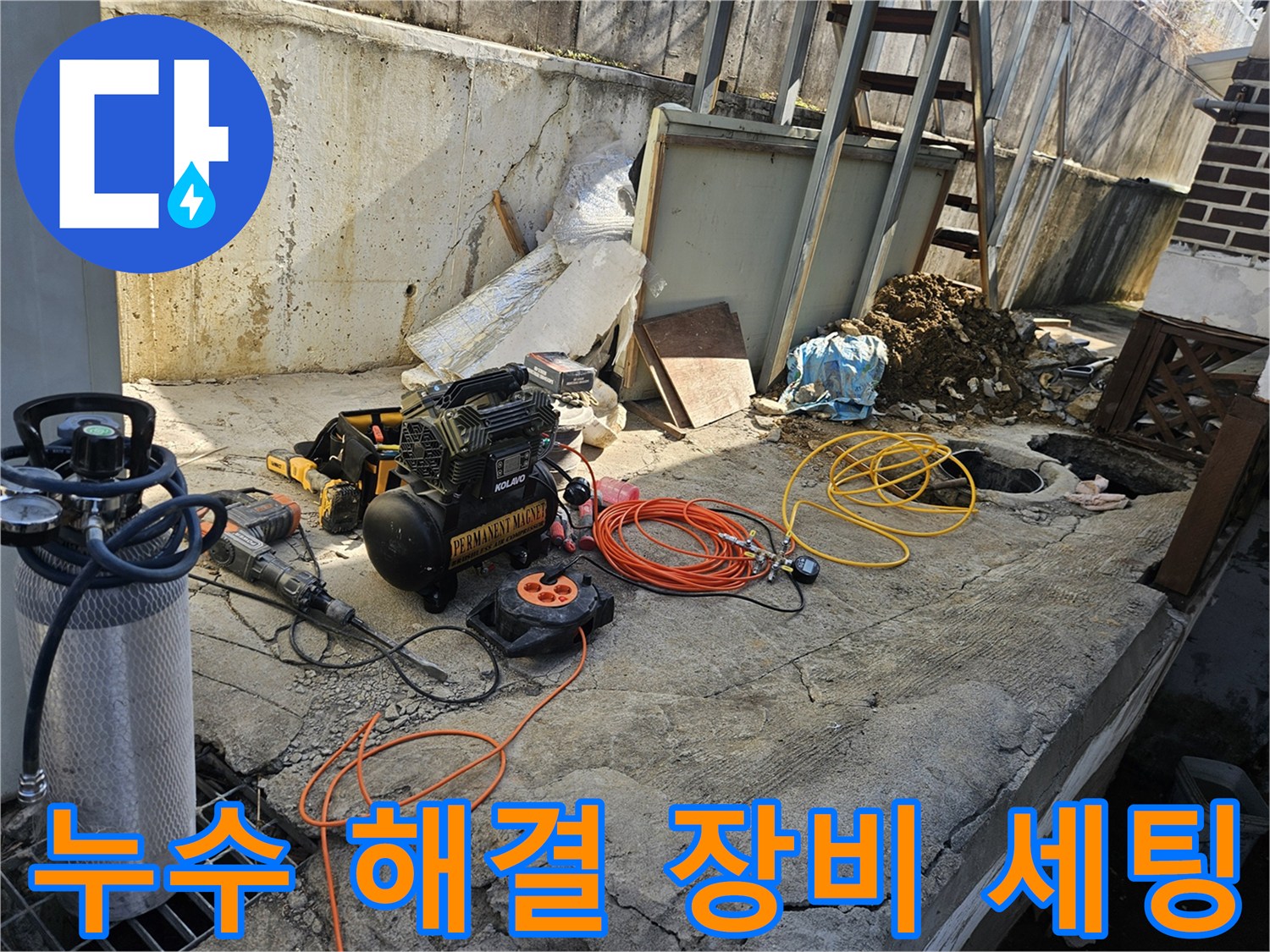 누수 공사 현장에서-에어 콤프레셔-함마드릴-호스-전선릴 등-다양한 전문 장비들이-콘크리트 바닥 위에-정돈된 채-작업 시작 전-준비를 마친 모습