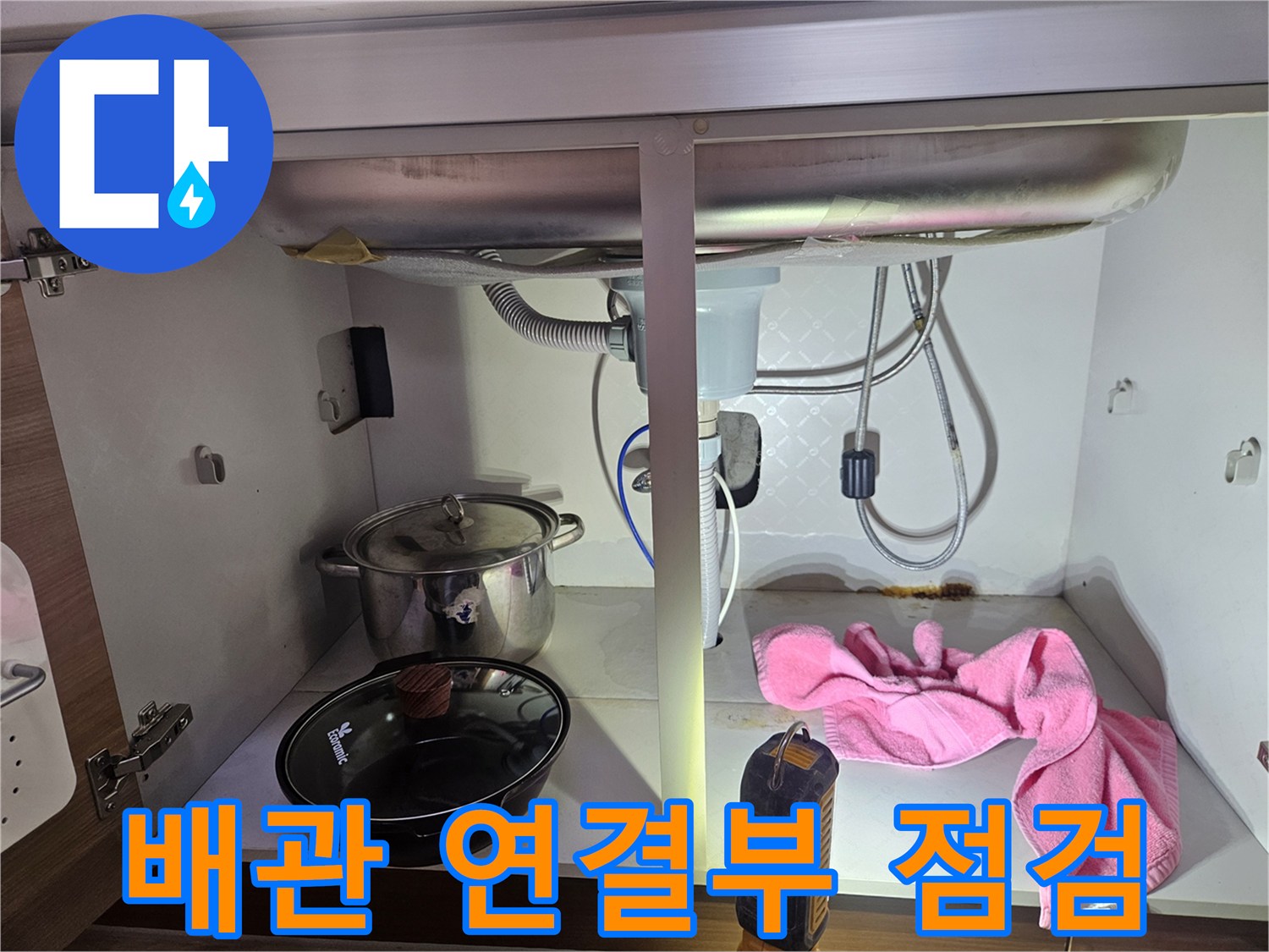 싱크대-하부의-배관-연결-부위에서-누수-여부를-정밀하게-점검하는-모습을-담은-사진입니다
