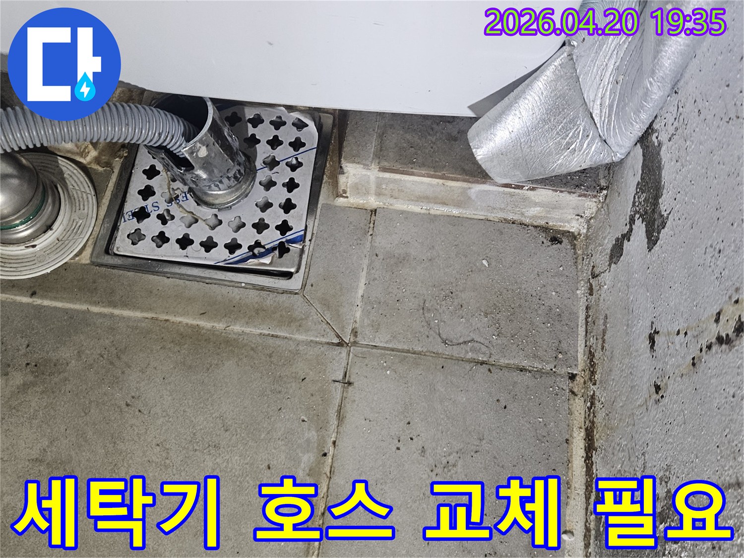 세탁기 배수 호스가-바닥 배수구에-연결된 모습으로-주변에 물때와-오염이 보이는-누수 현장 사진입니다.
