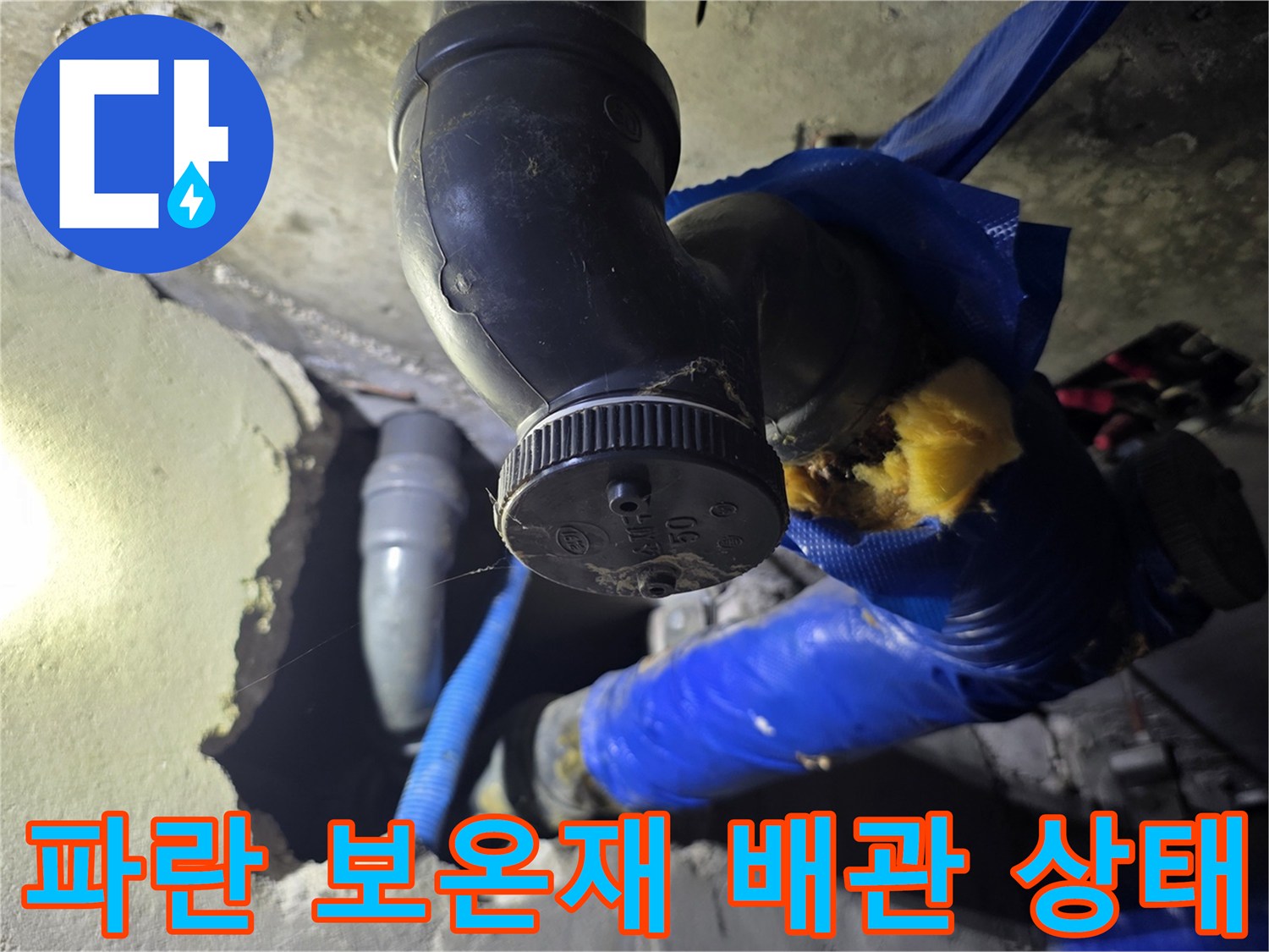 손상된 파란색 보온재와 노출된 배관 연결 부위의 모습