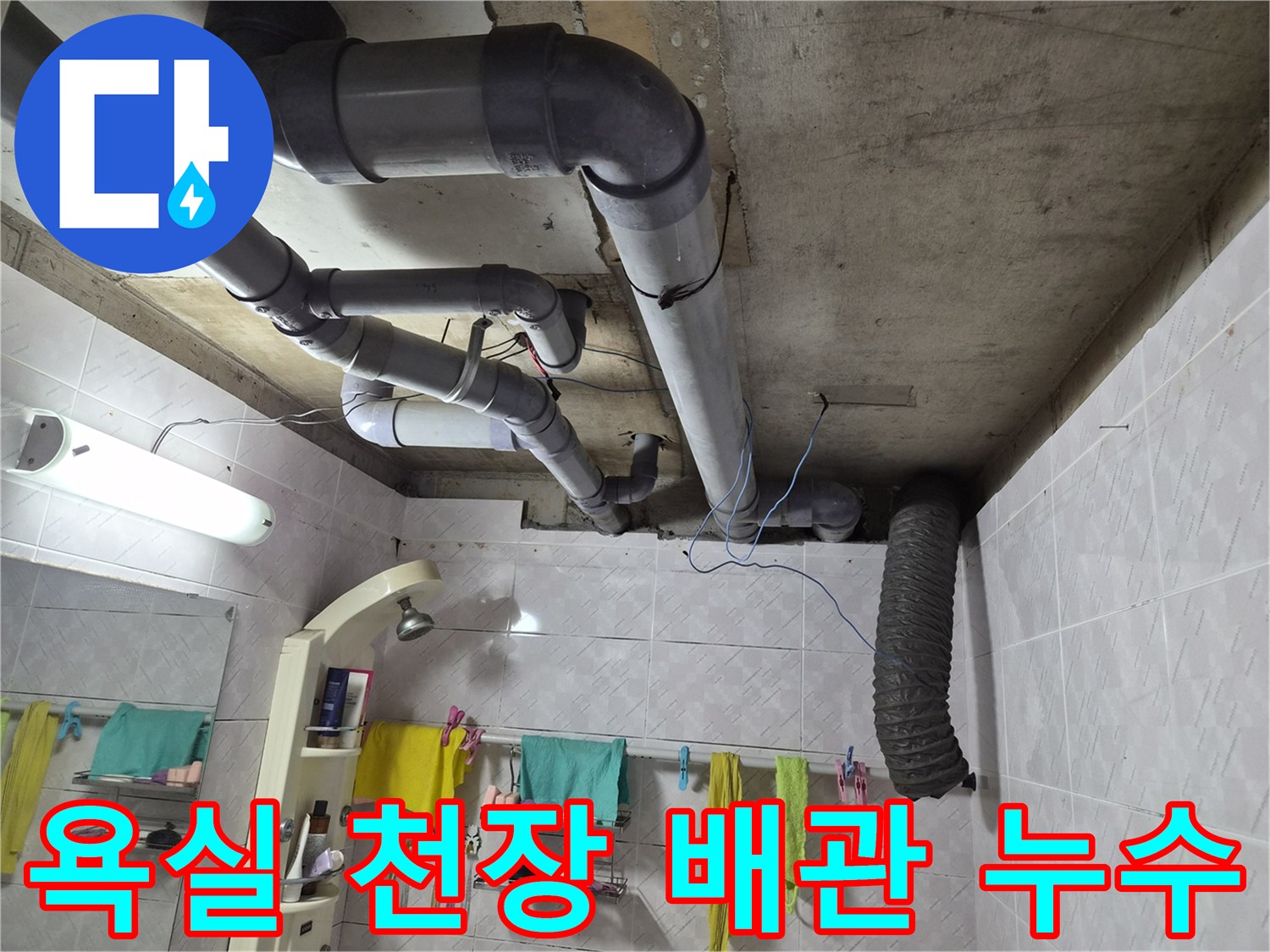 이 이미지는 주거 공간의 욕실 천장에 설치된-회색 배수관들이 복잡하게 연결된 모습을 보여줍니다-누수 문제의 원인을 파악하기 위한-현장 진단 과정의 일부입니다