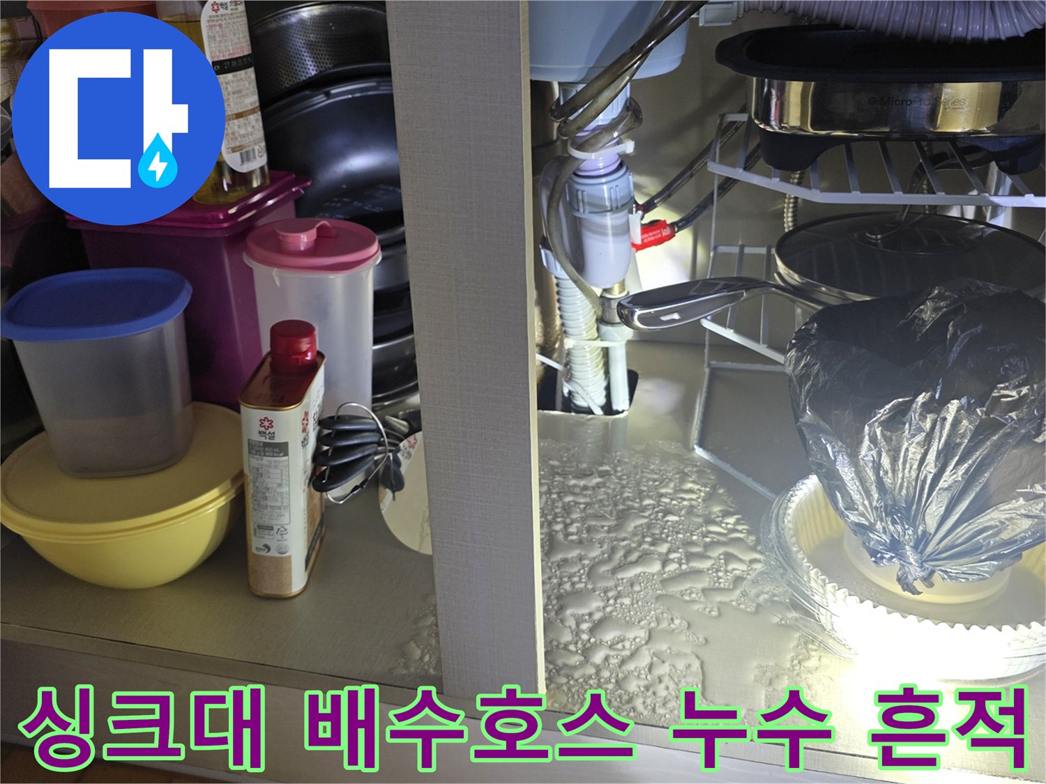 싱크대 하부장 내부-물기가 고여 있는 배수 호스 연결 부위 상세 컷