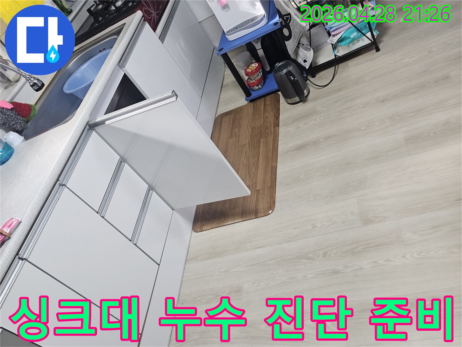 아파트 싱크대에서 발생한 누수를-정밀하게 진단하기 위한-준비 작업을 보여주는 이미지입니다.