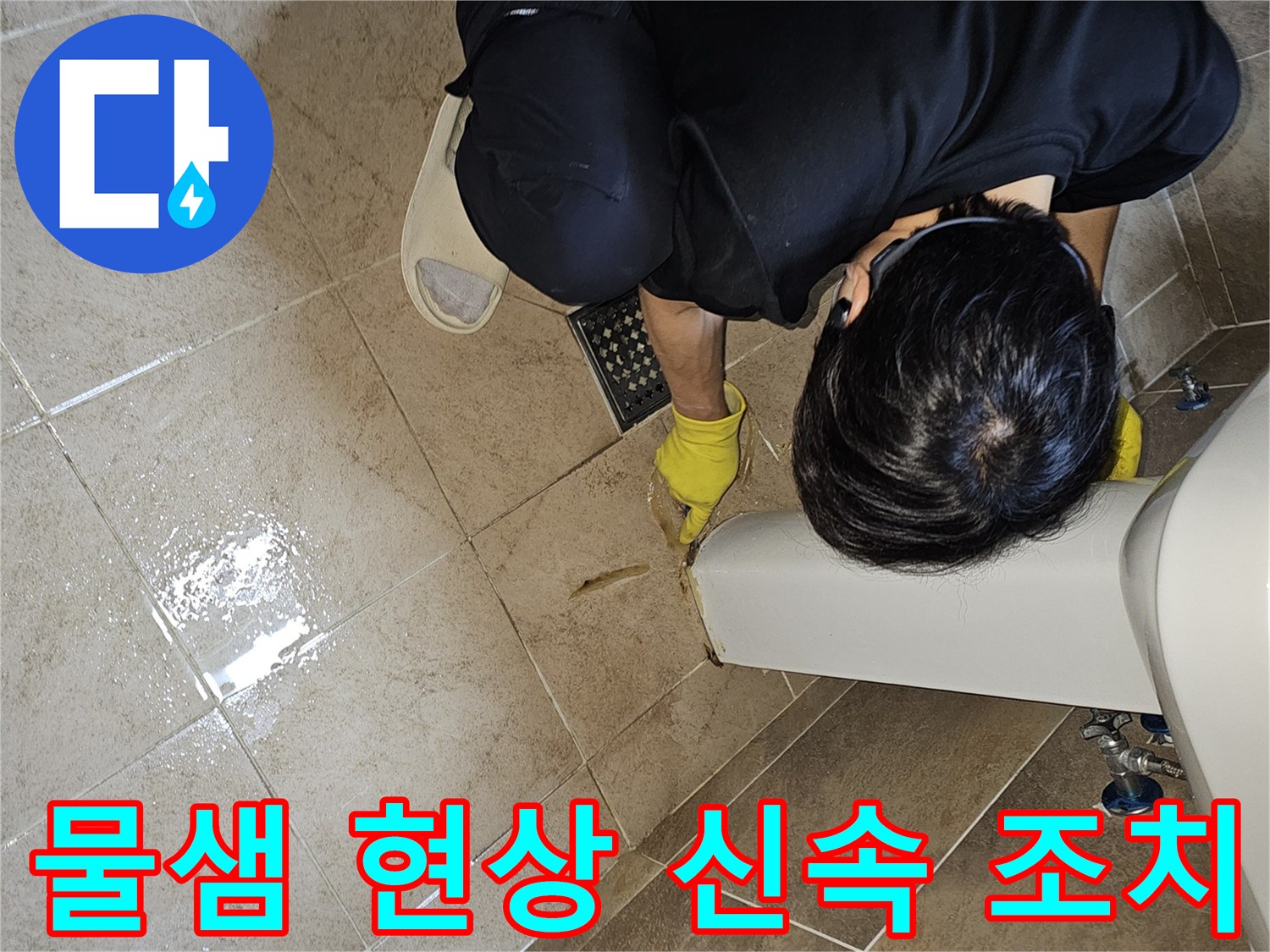 전문 엔지니어가-노란 장갑을 끼고-욕실 바닥의 젖은 타일과-세면대 하단부를-집중적으로 관찰하며-누수 지점을 신속하게 확인하고 있습니다