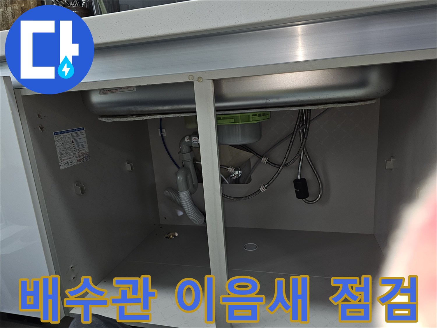 싱크대 하부 배수관의 이음새 부분을 집중적으로 보여주는 이미지로-누수 발생 가능성이 높은 연결 부위를 정밀하게 점검하고 있습니다.
