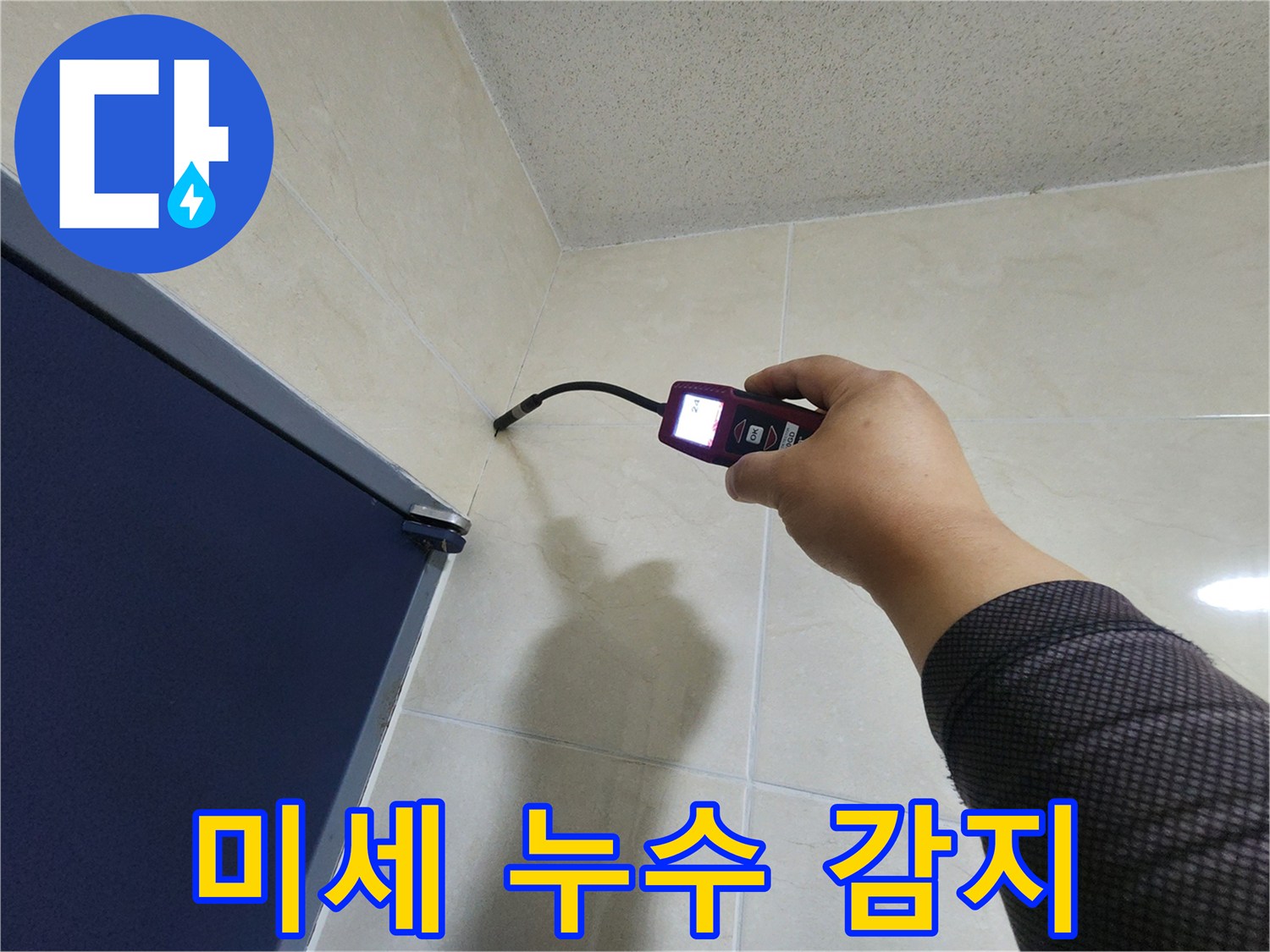 누수 전문가가-고감도 센서가 장착된-탐지 장비로-벽면 내부의 미세한 습기를-정확하게 감지하고 있습니다.
