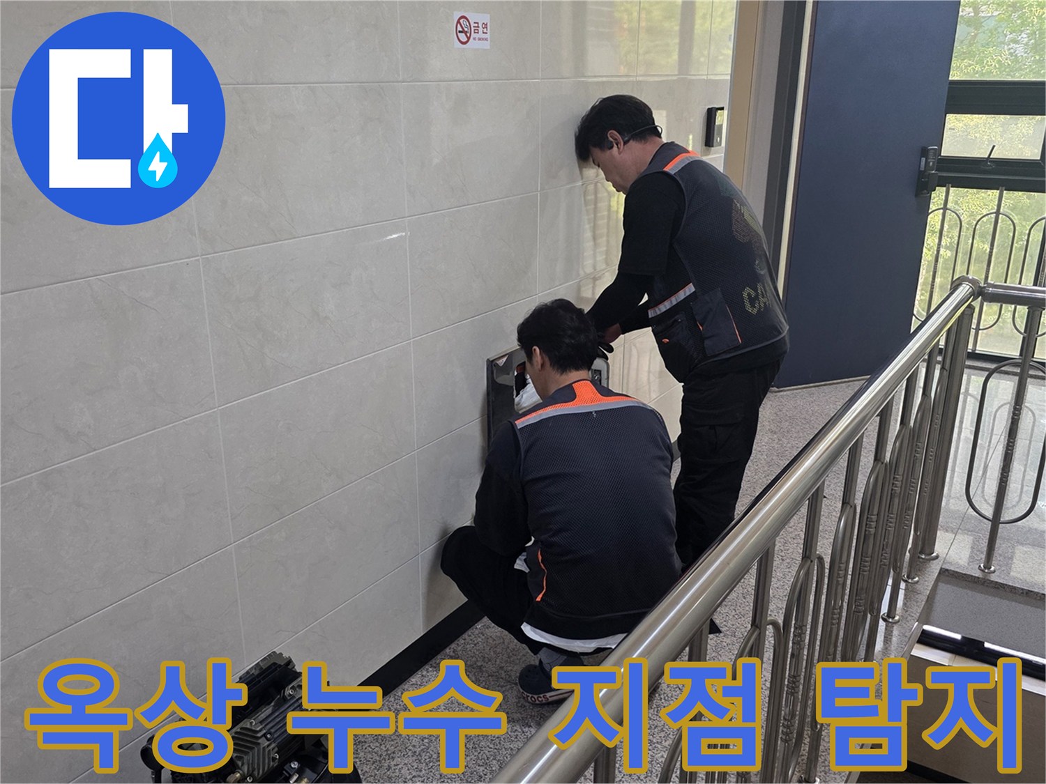 두 명의 전문 기술자가 건물 벽면의 옥상 누수 의심 지점을 정밀하게 탐지하고 있습니다-건물 수명 연장과 안전 확보를 위한 중요한 작업입니다.