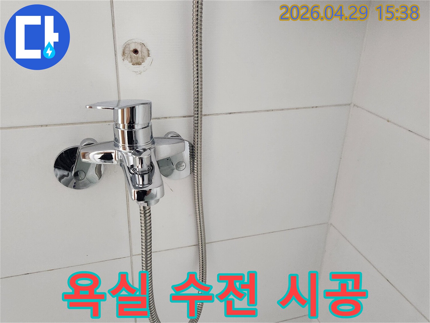 가리봉동 욕실에-새롭게 설치된-크롬 샤워 수전이-하얀 타일과 잘 어우러진-모습을 보여줍니다.