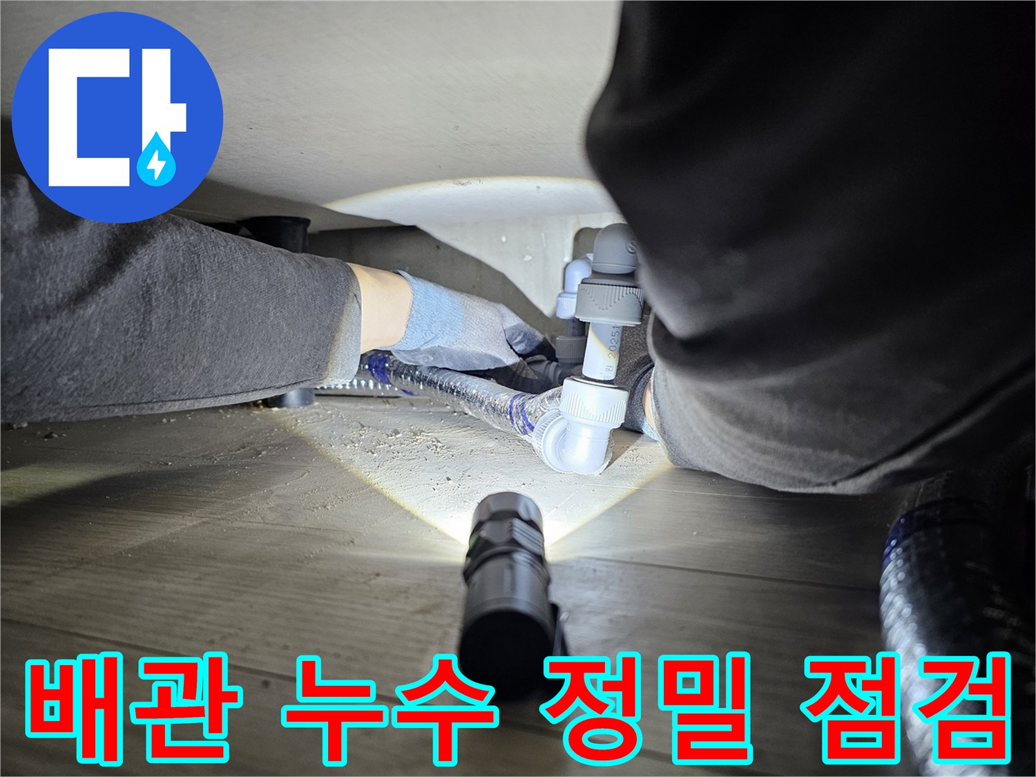 누수-탐지-전문가가-어두운-공간에서-배관-연결부를-확인하는-모습
