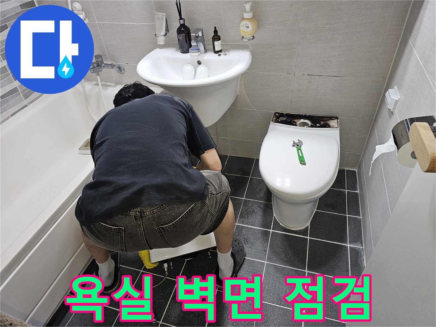 아파트-욕실에서-누수-탐지를-위해-세면대-주변-벽면을-조심스럽게-점검하는-작업