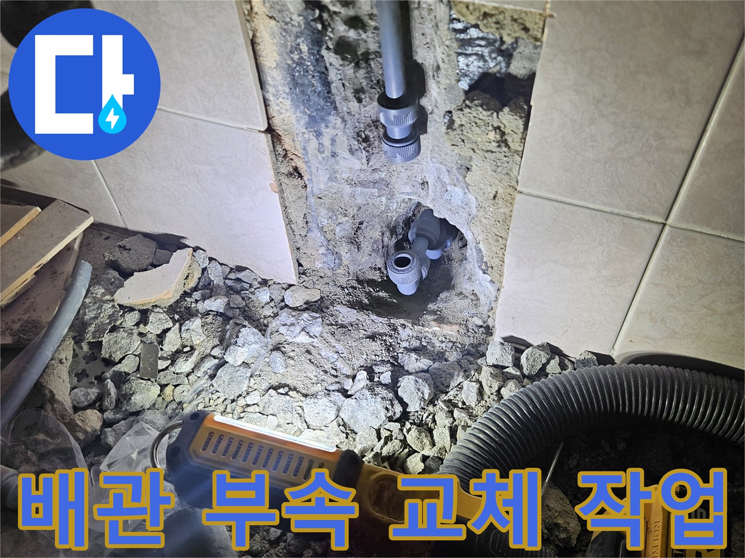 굴착된 벽면 내부에 노출된 수도 배관과 작업용 전동 공구
