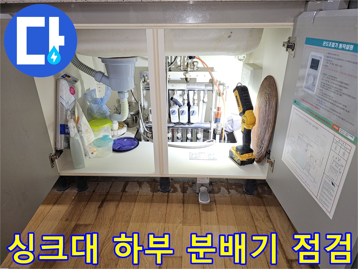성동구 금호동 싱크대 하부장 내부의 복잡한 배관과 분배기 상태를 확인하는 모습