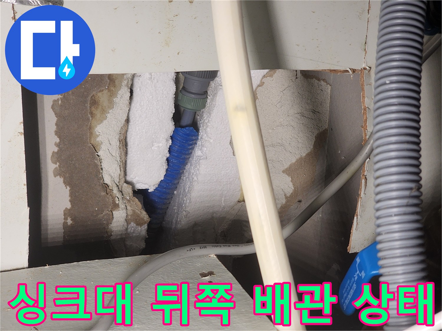 싱크대 하부장 뒷면 벽체 내부의 파란색 온수 배관과 단열재 모습