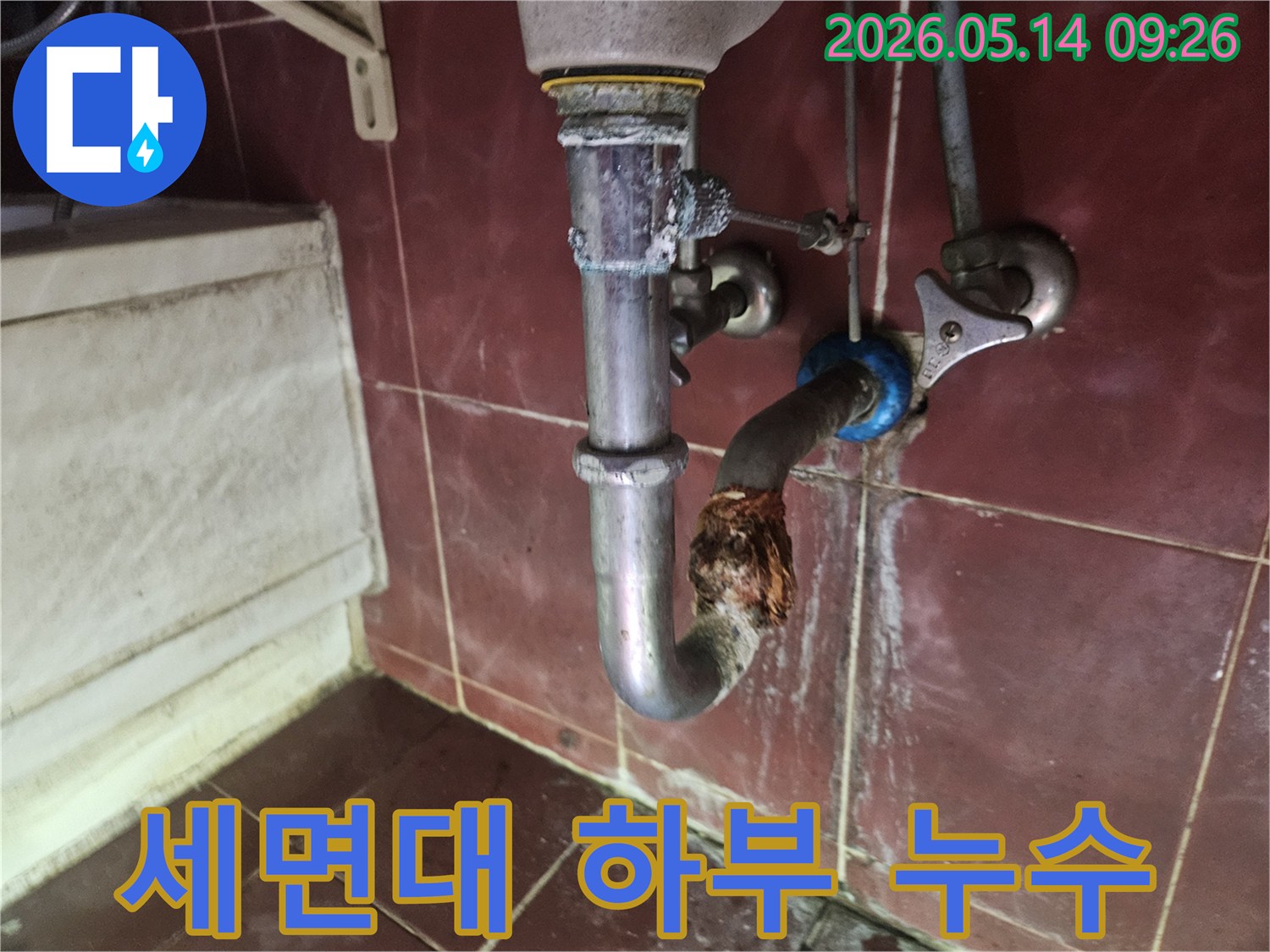 세면대 하부 배수관에서 발생한 심각한 부식과-누수 현장을 보여주는 사진입니다.