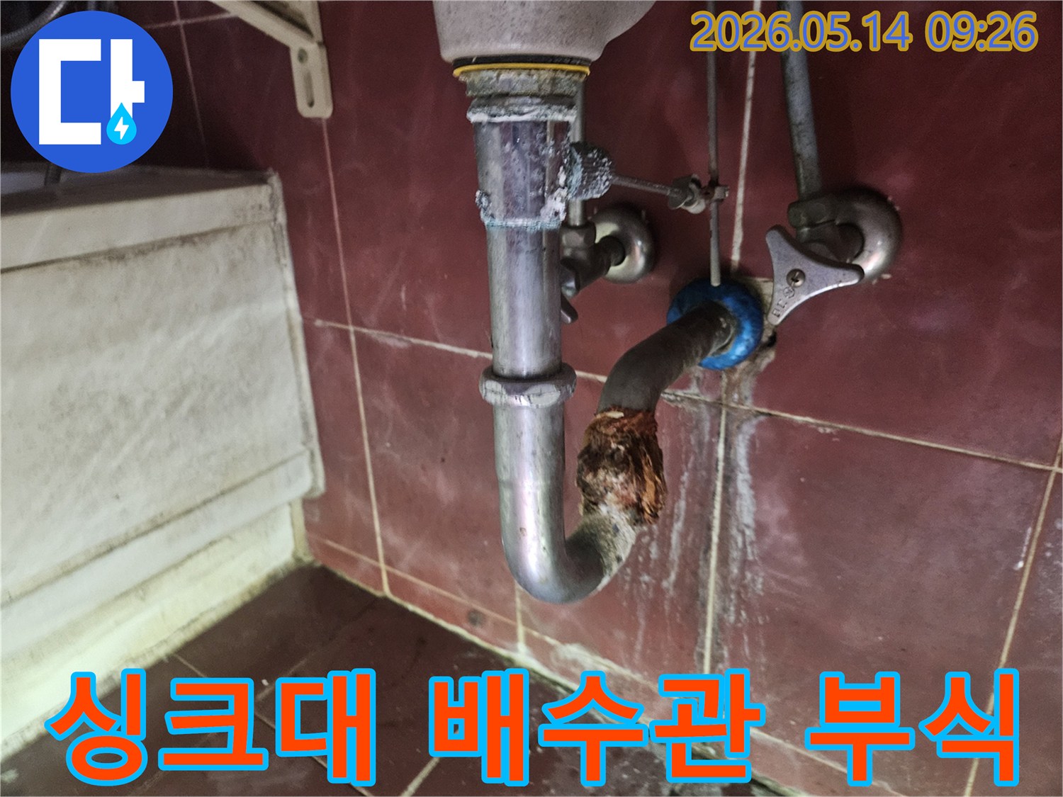 오래된 싱크대 배수관에서 발생한 심각한 부식-누수 현장을 보여주는 사진입니다.