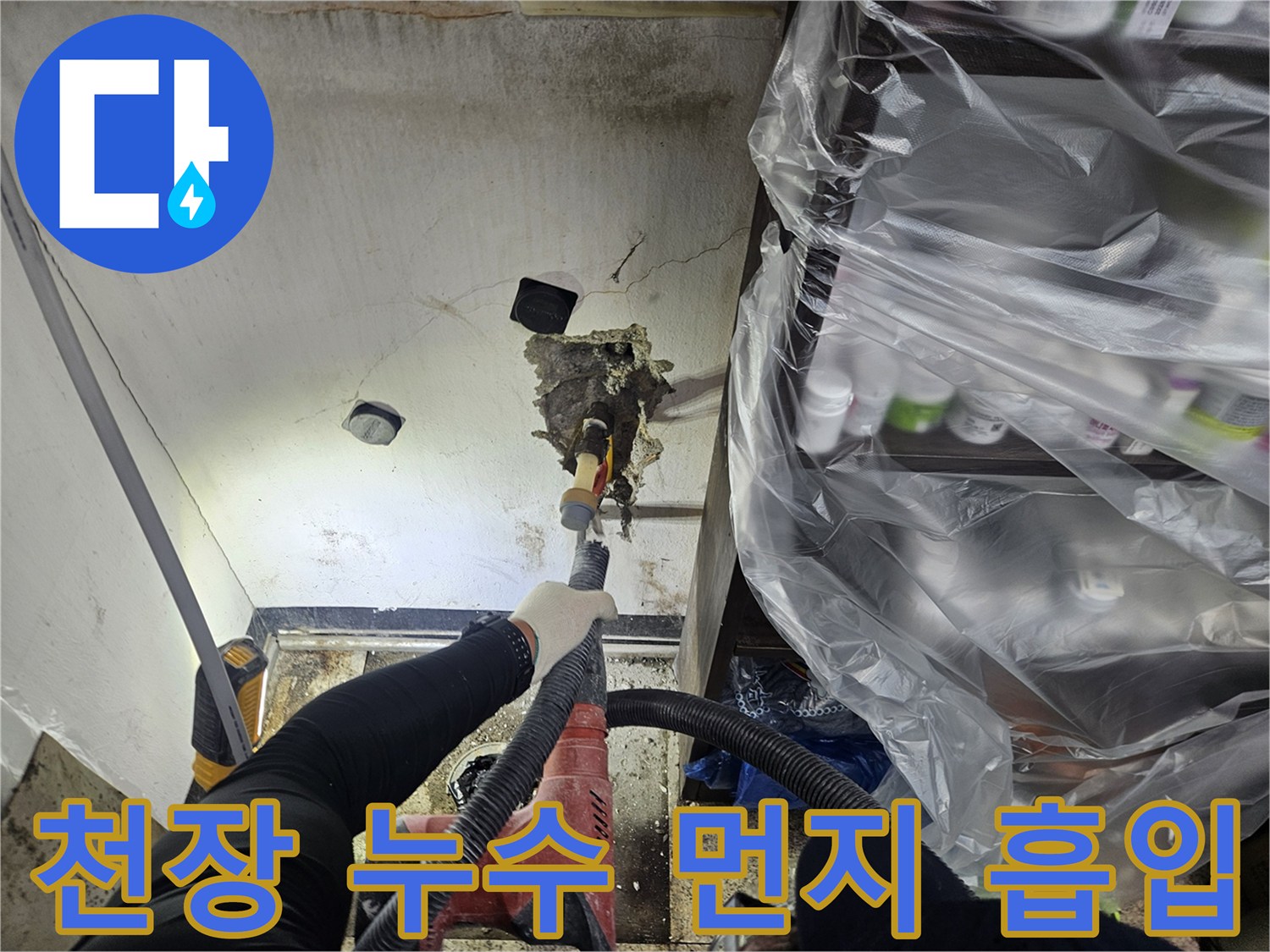 누수 탐지 작업자가-천장 타공 중 발생하는 먼지를-전용 흡입 장비로 깨끗하게 제거하고 있습니다