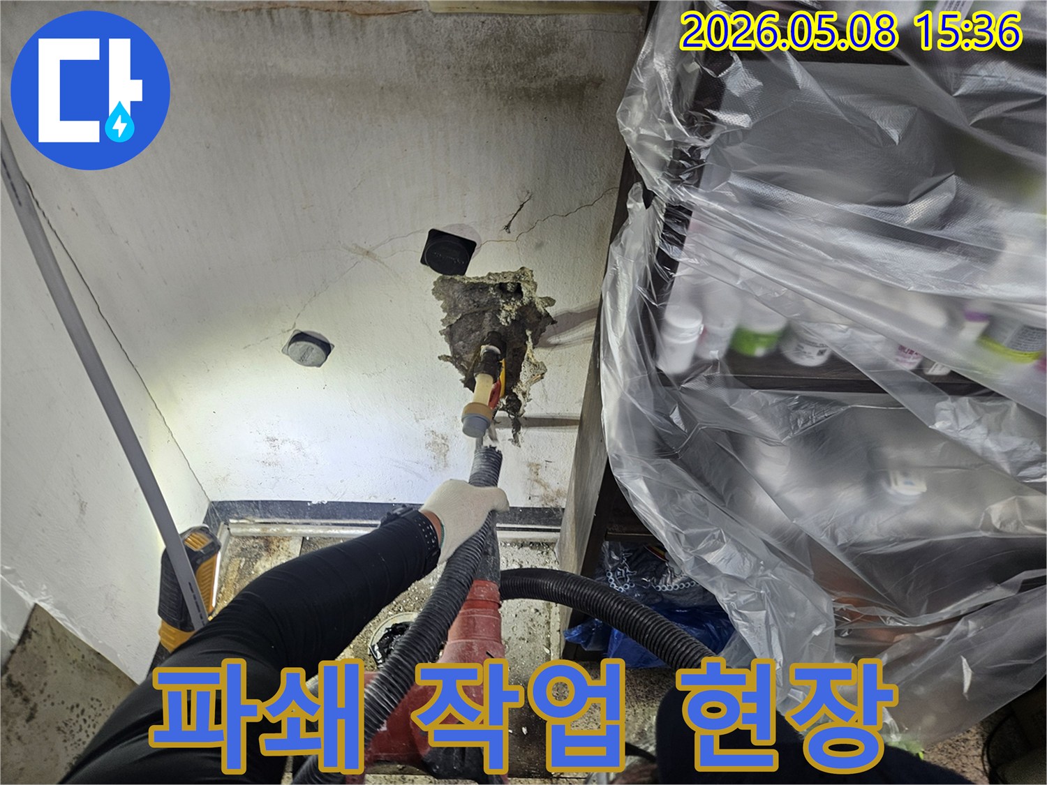 천안 누수 전문 엔지니어가-천장 누수 원인인-배관을 수리하기 위해-파쇄 작업을 진행하며-동시에 먼지 흡입 장비를-사용하는-모습입니다