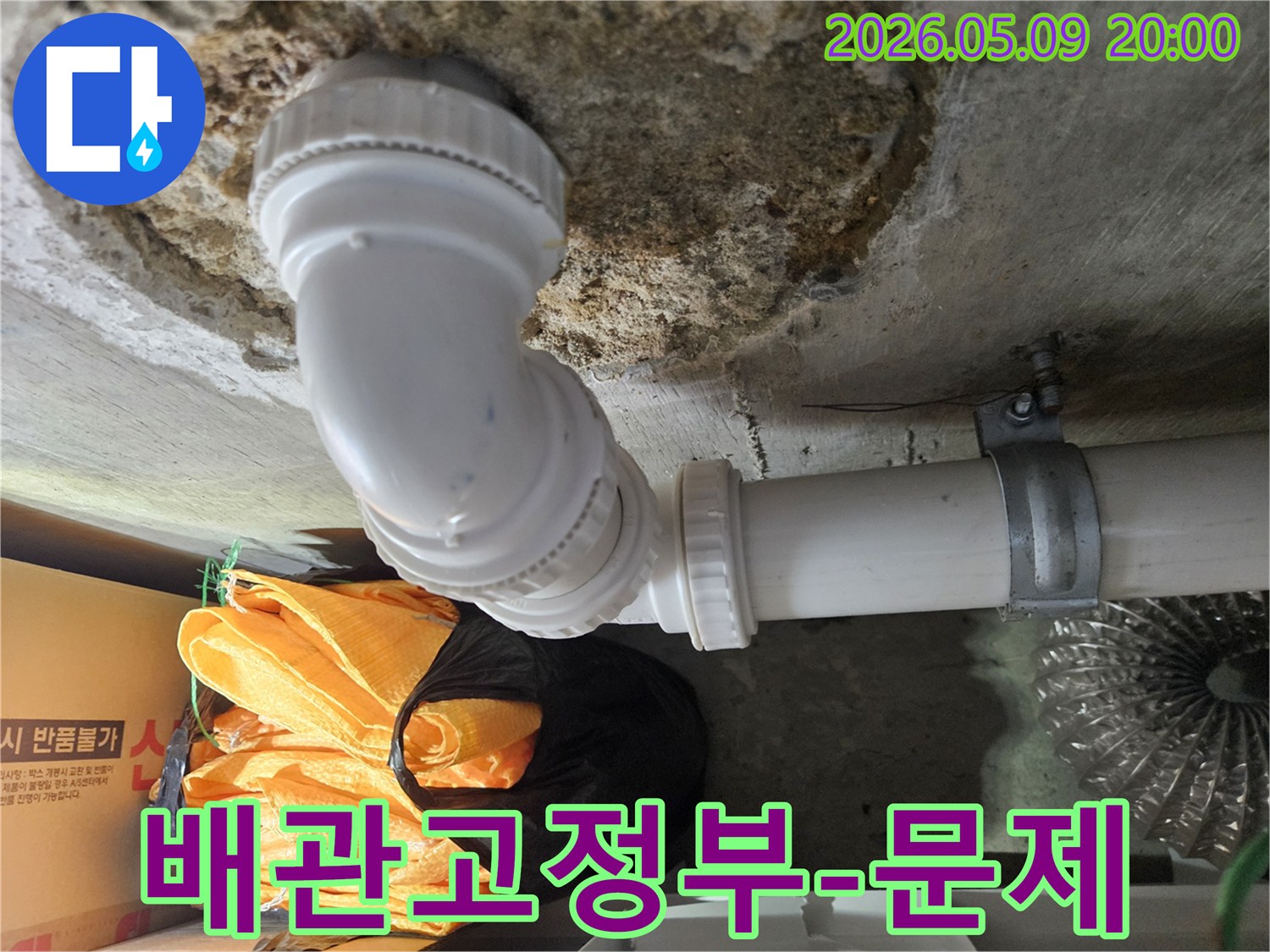 지하 주차장 천장에 설치된 배관의-고정 부위에서 발견된-누수 흔적을 전문가가 분석하는 장면입니다