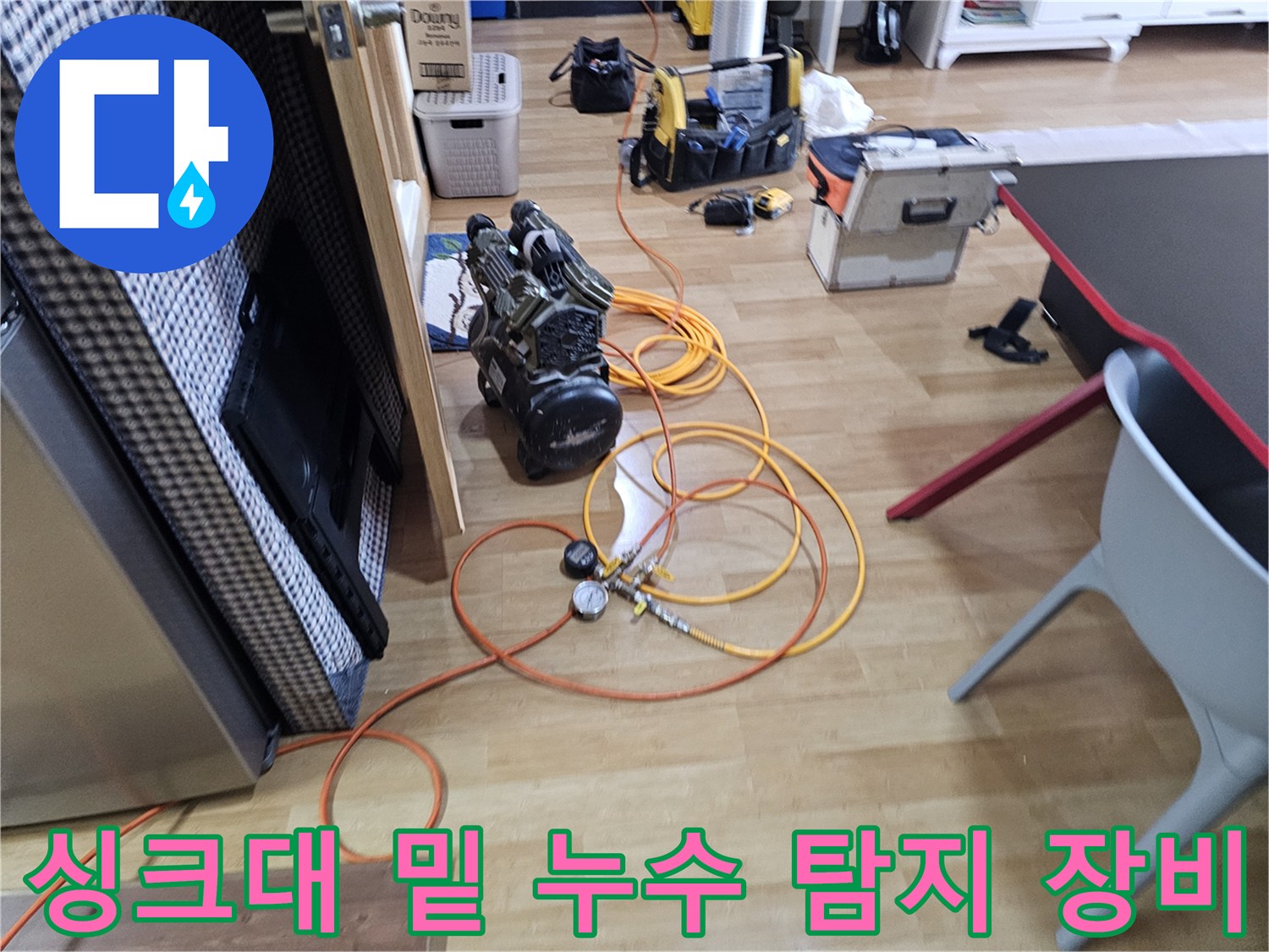 주방 싱크대 하부 공간에 놓인 가스식 누수 탐지기와 전문 측정 장비들입니다.