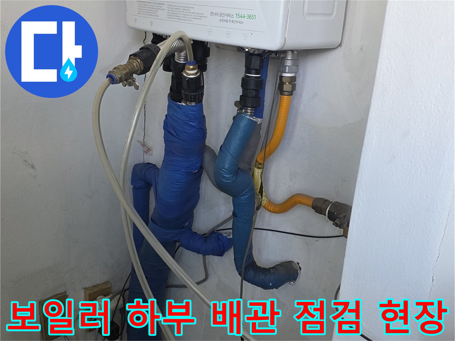 보일러 아래쪽의 보온재로 감싸진 수도 배관과 연결 부위 상세