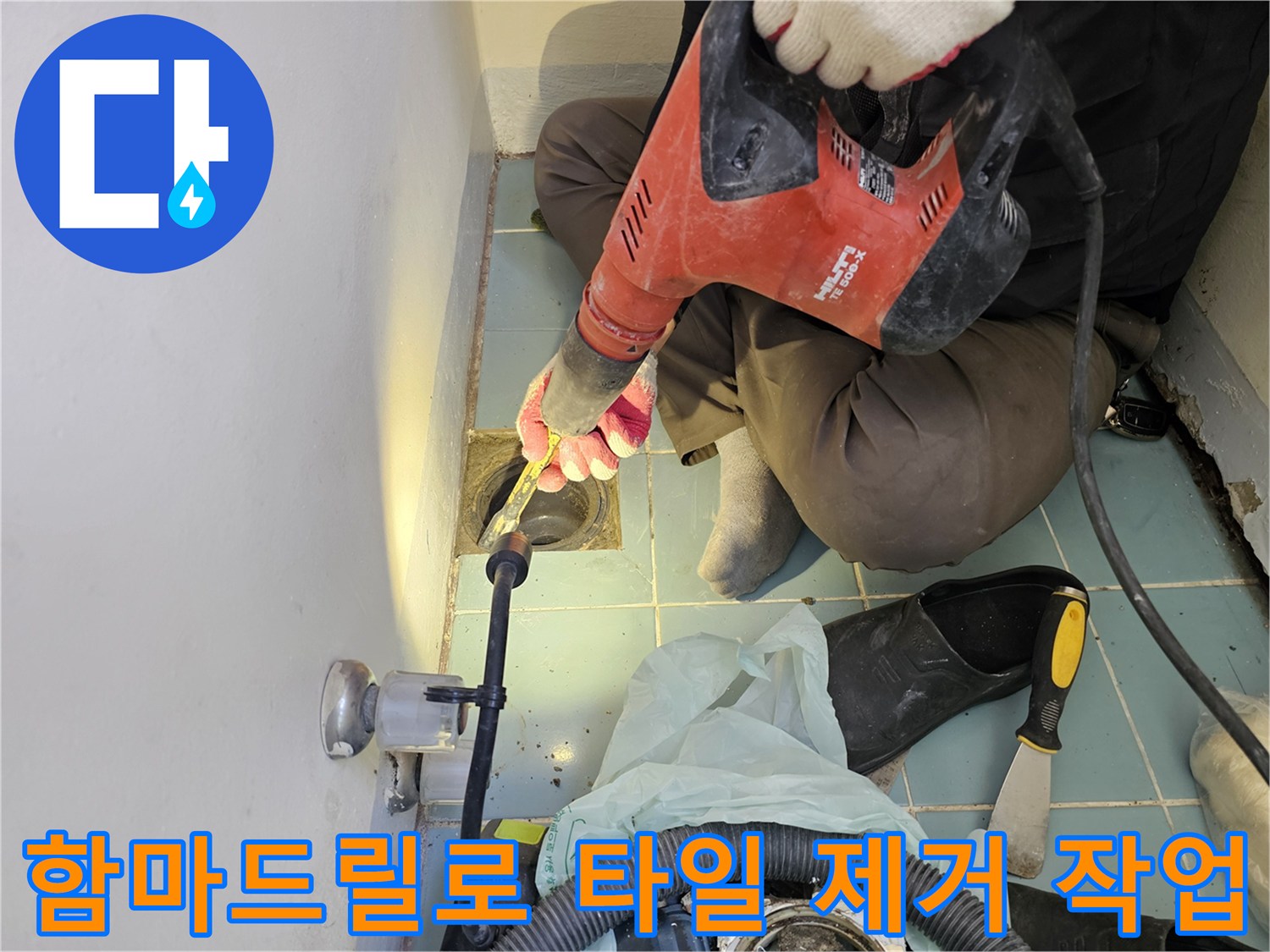 함마드릴을 사용하여-배수구 주변의 노후된 타일을 정교하게 파쇄하는 모습