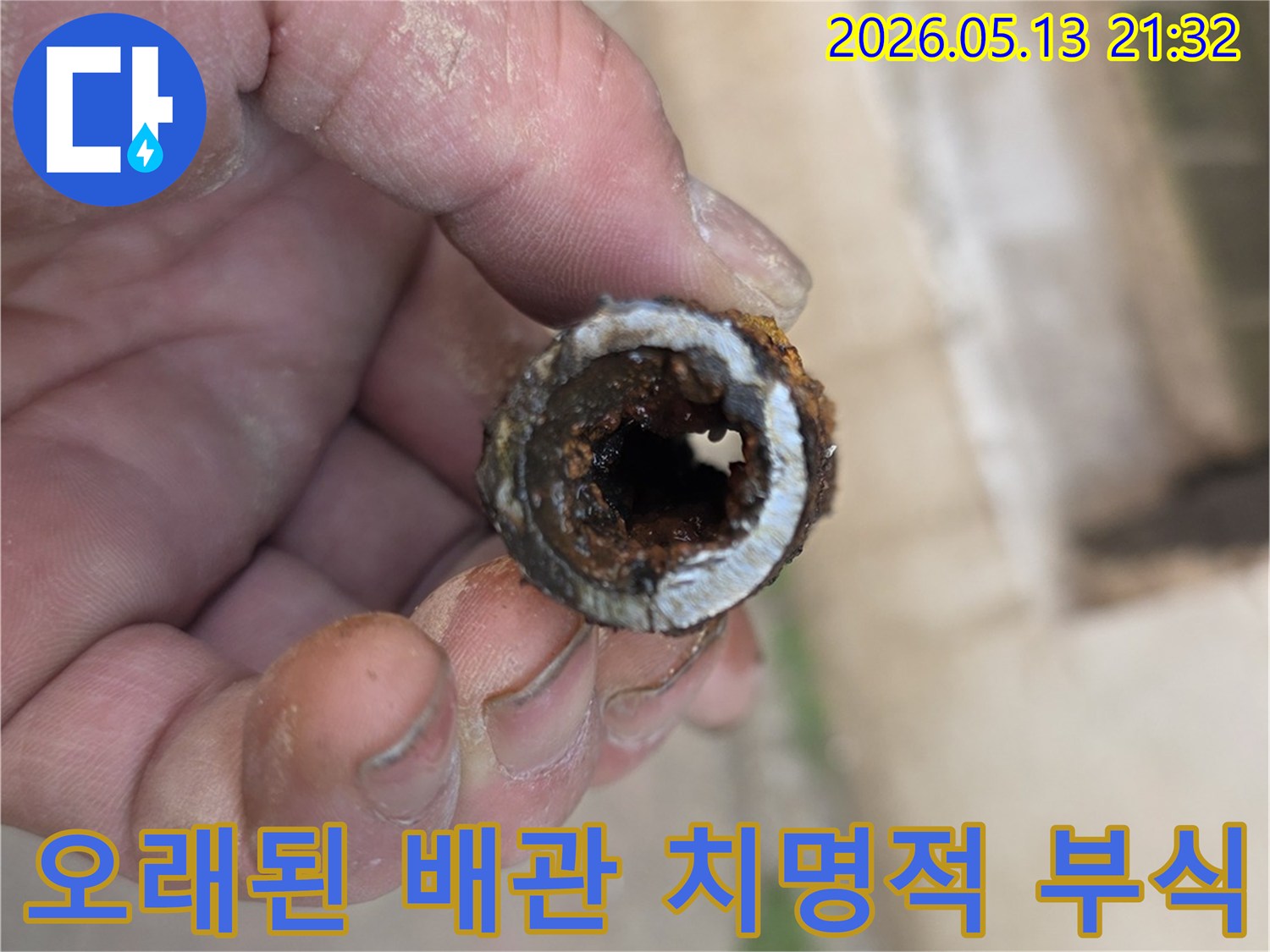 오래된 주택의 수도관에서 발견된-치명적인 수준의 내부 부식을-전문가가 고객에게 직접 설명하는 이미지입니다