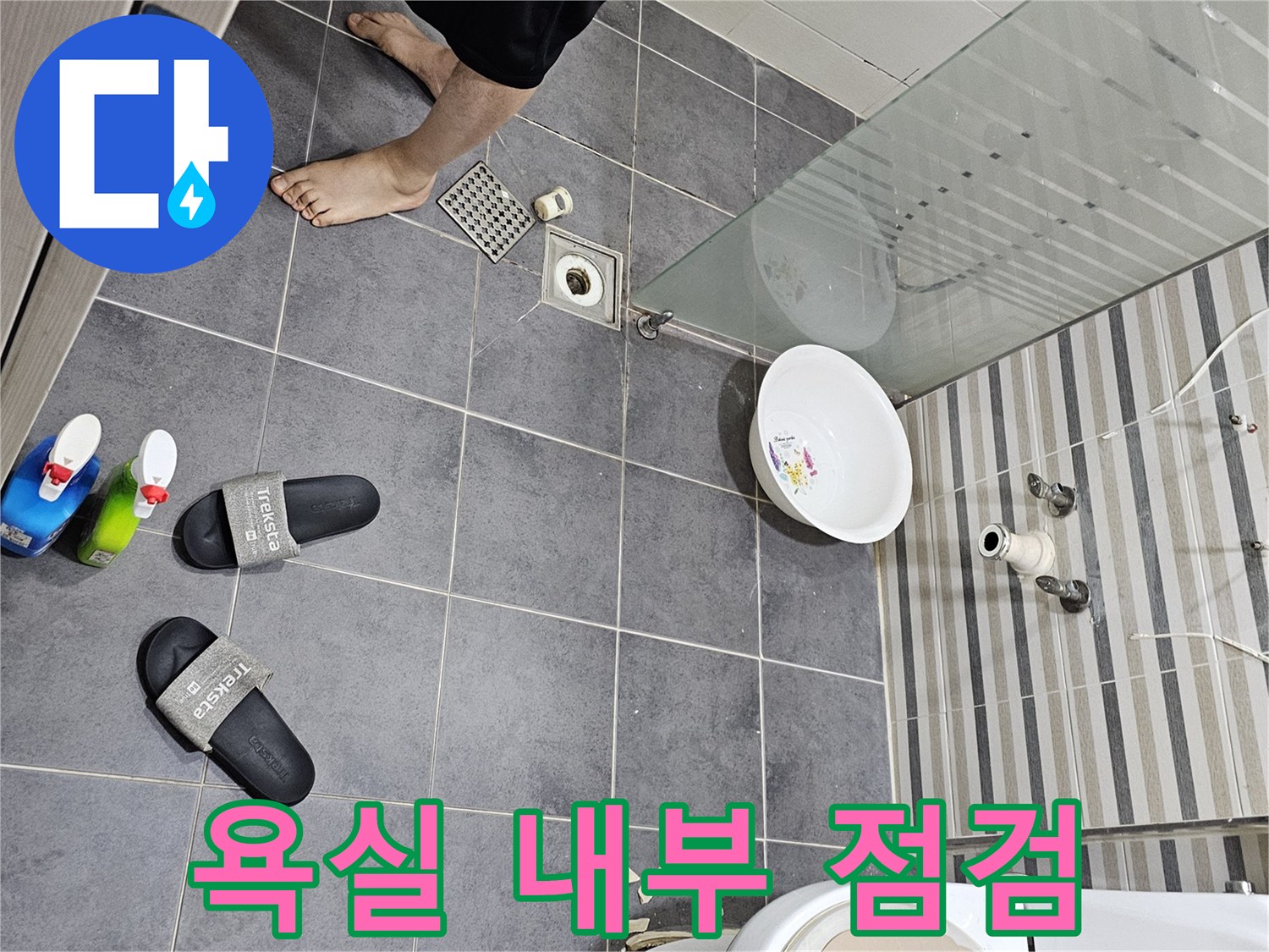 변기와 세면대 하부 배관이 보이는 화장실 바닥 이미지
