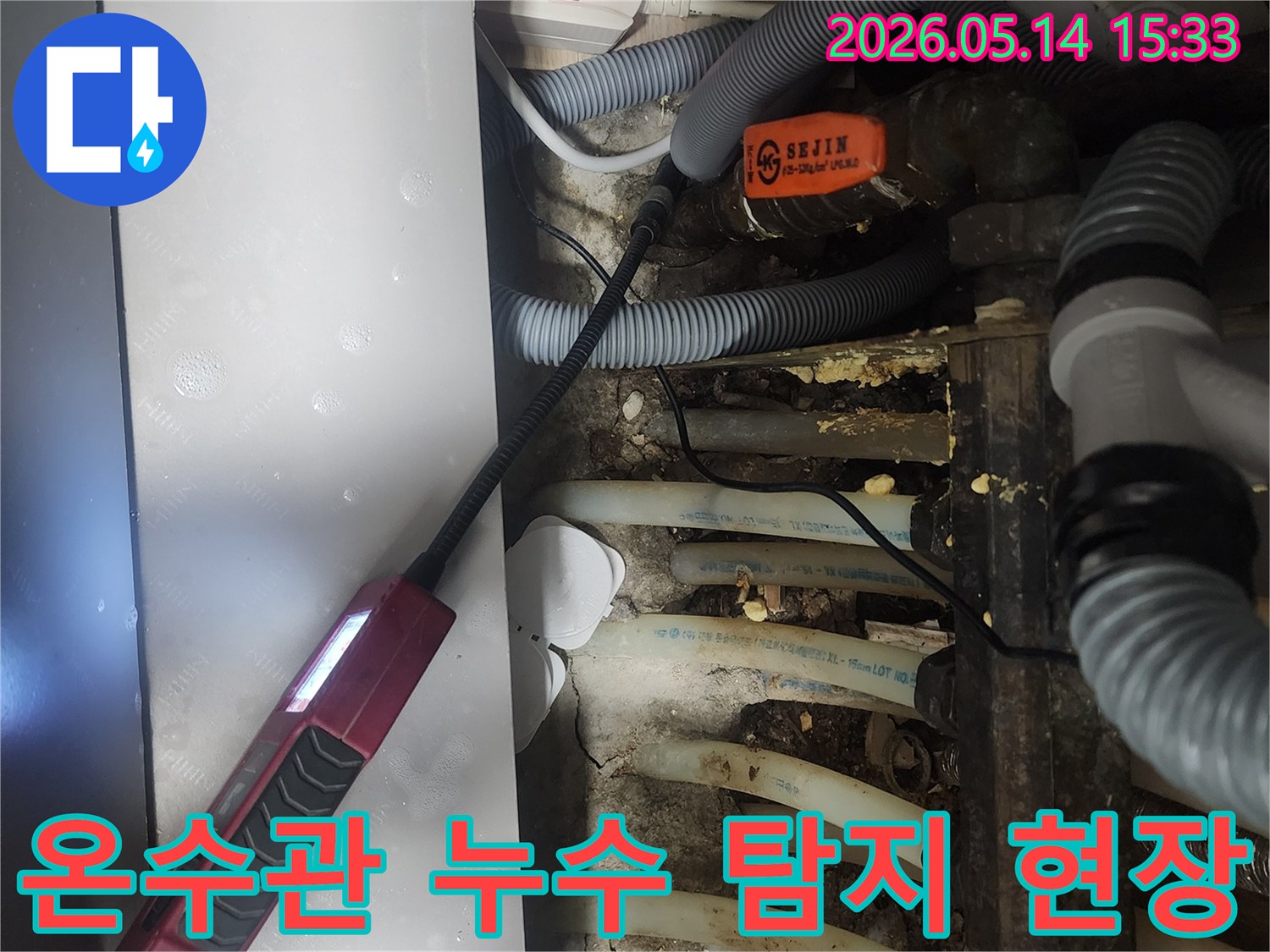 복잡하게 얽힌 온수 배관 사이에서-누수 지점을 찾아내기 위한-정밀 검사가 진행되는 장면