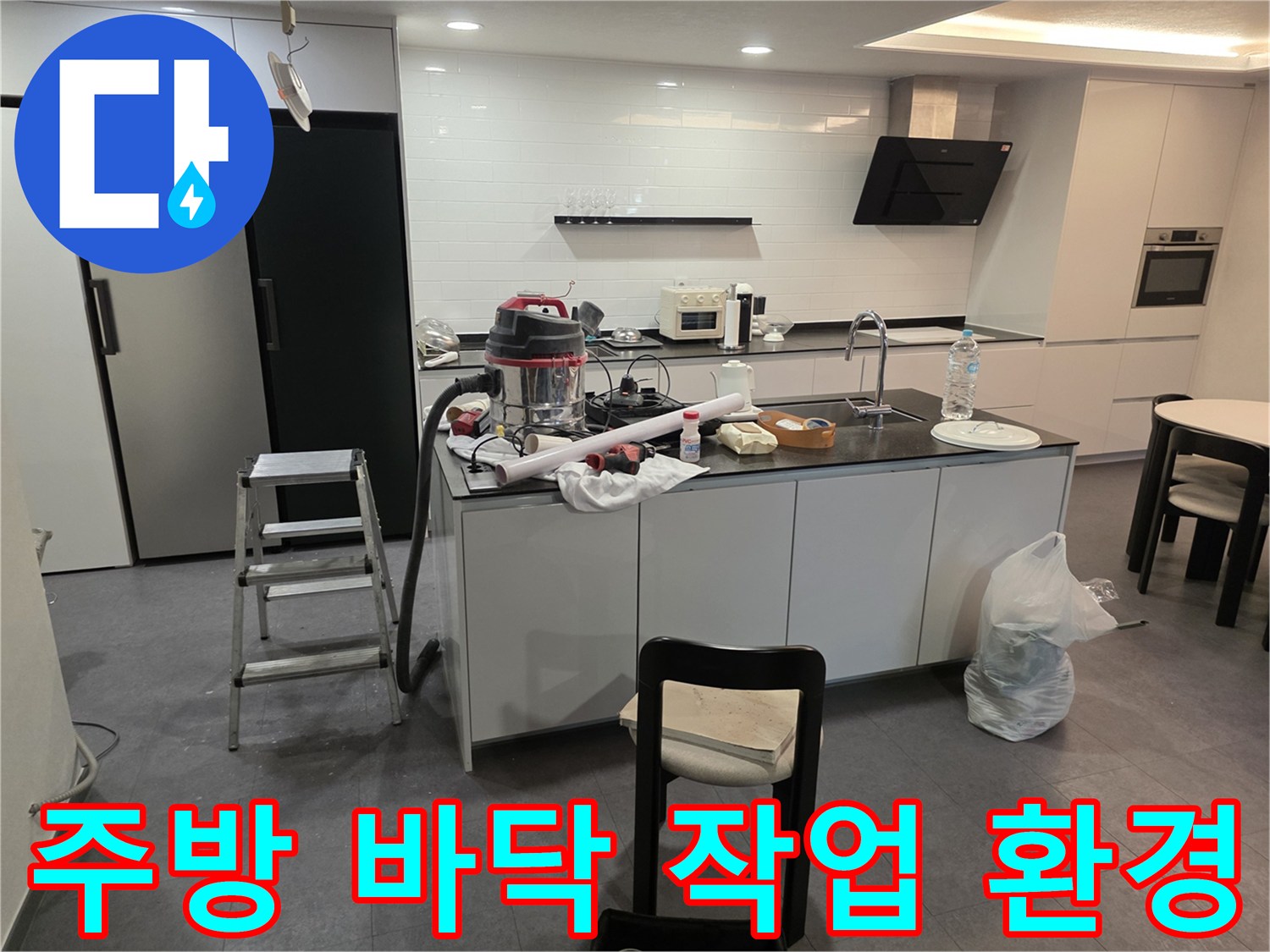작업을 위해 싱크대 아래에 배치된 청소기와 공구함