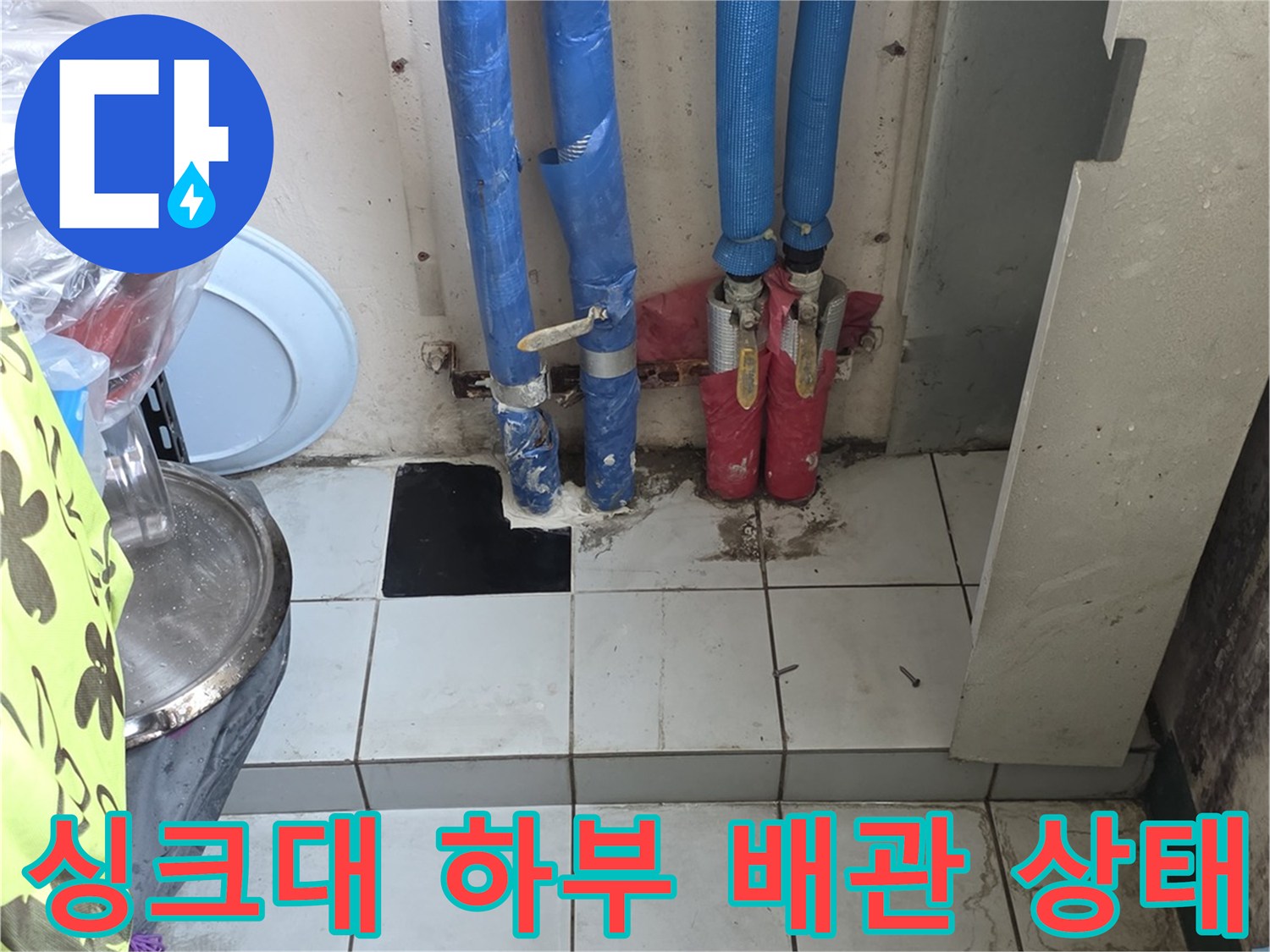 주방 싱크대 하단-파란색 보온재로 감싸진 배관과 연결 부위 모습