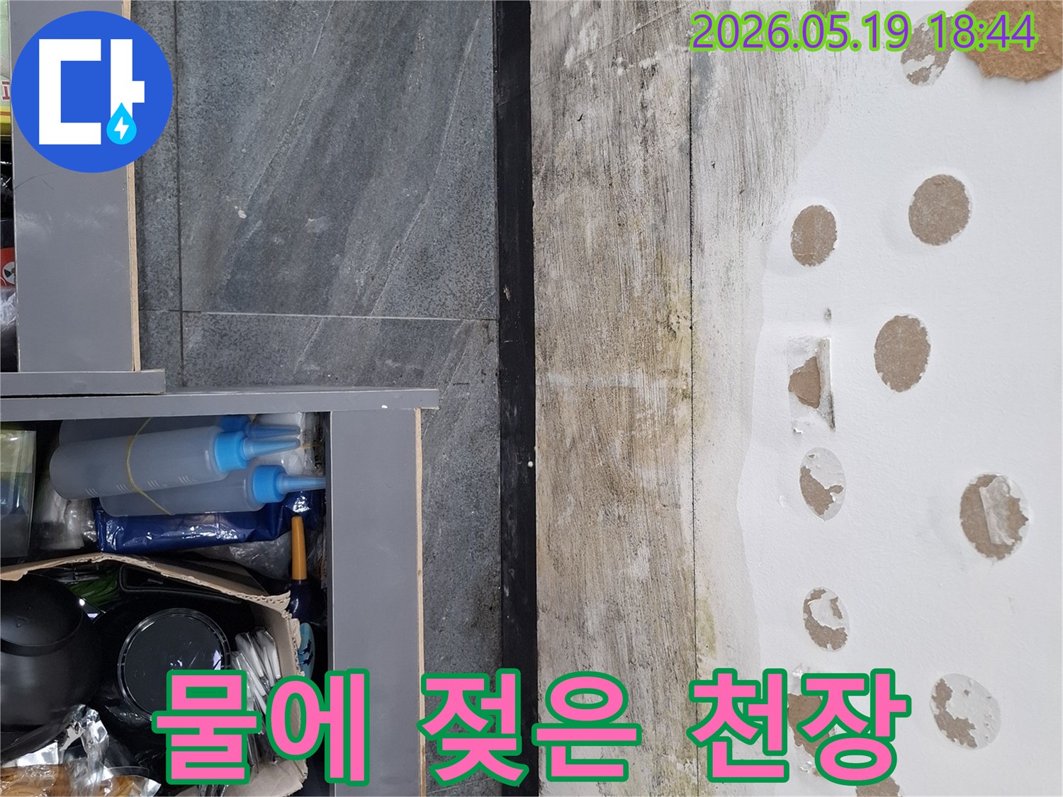 물샘 현상으로 인해 천장 석고보드가 부식되고-페인트가 벗겨진 상황을 보여줍니다.
